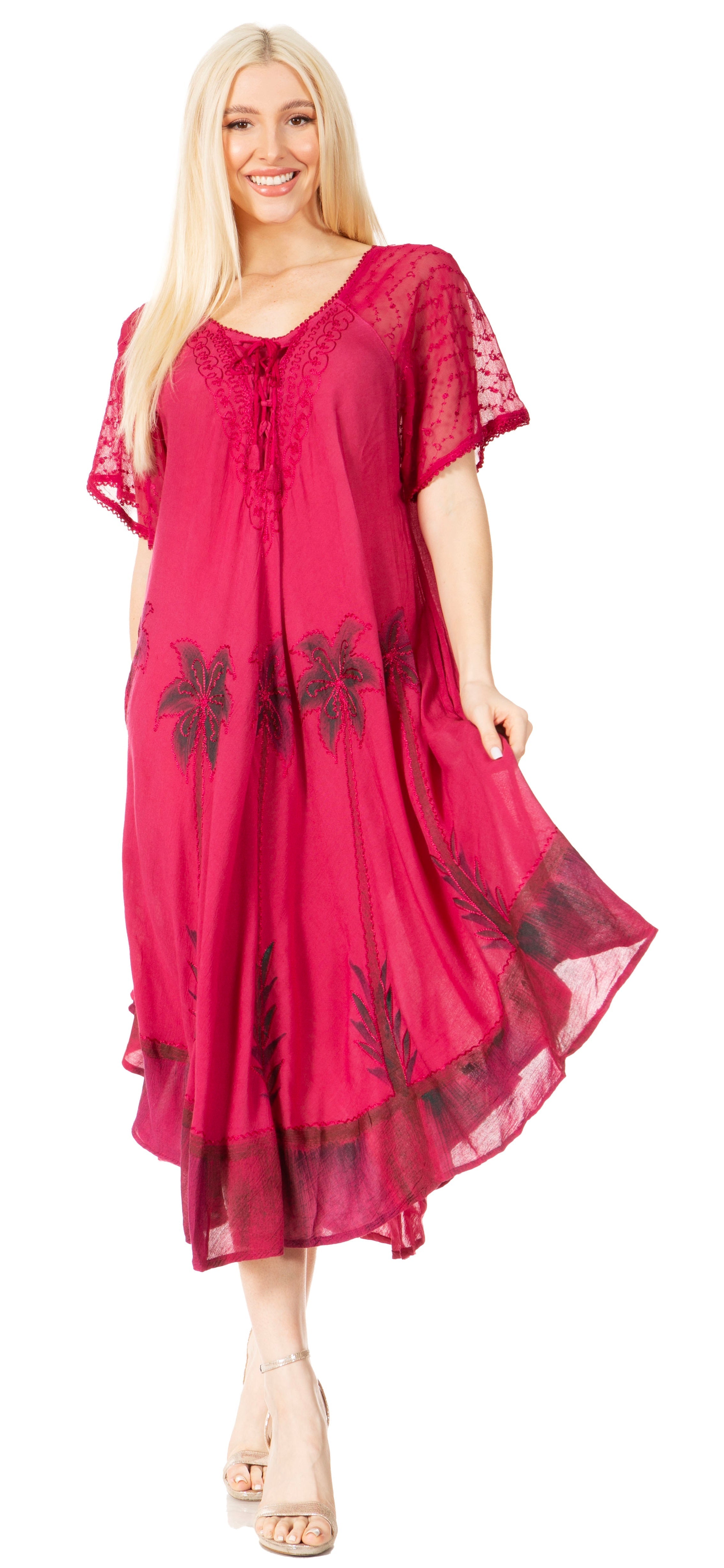 Woman wearing a pink dress with black floral patterns on a white background