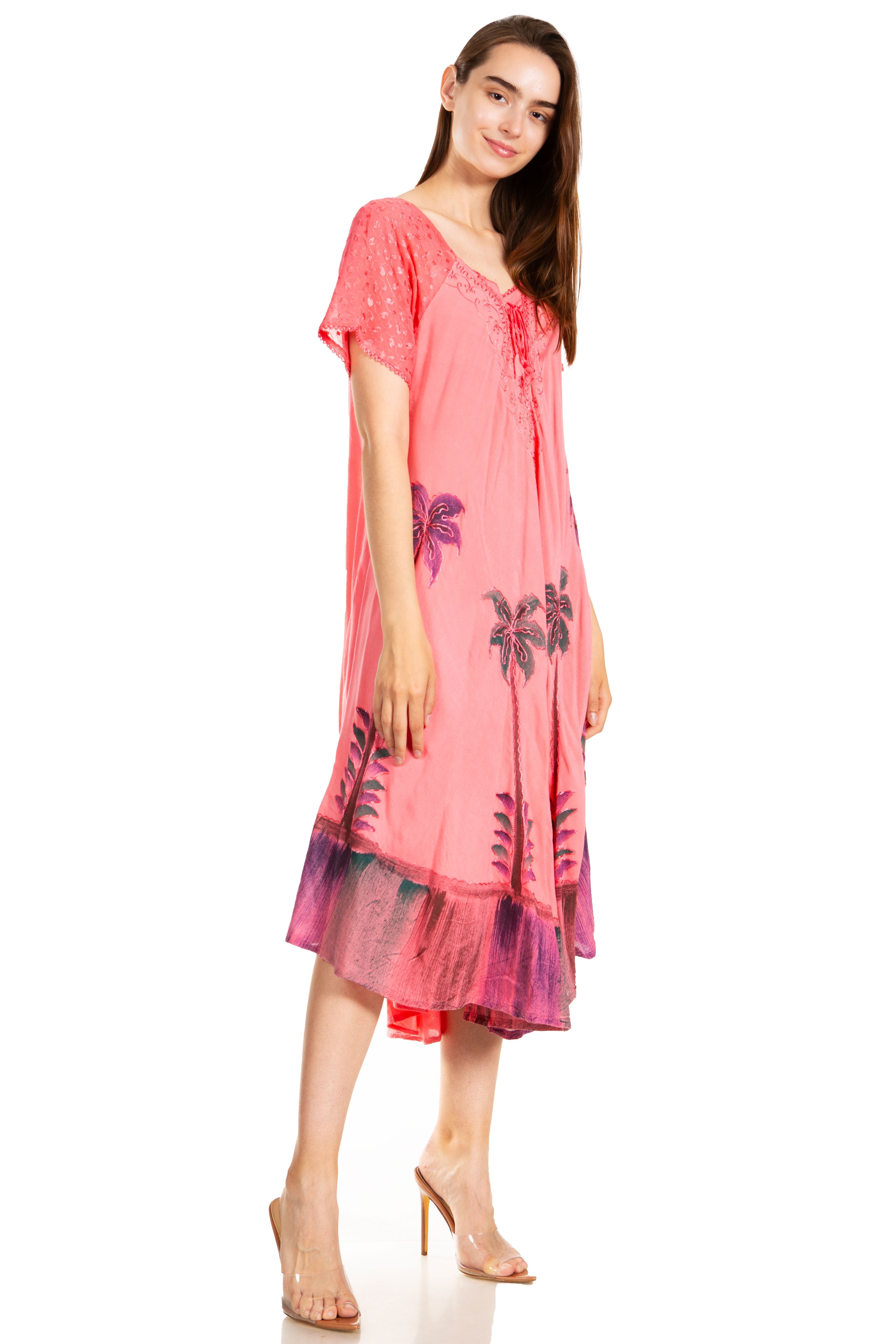 Woman wearing a pink dress with floral patterns on a white background