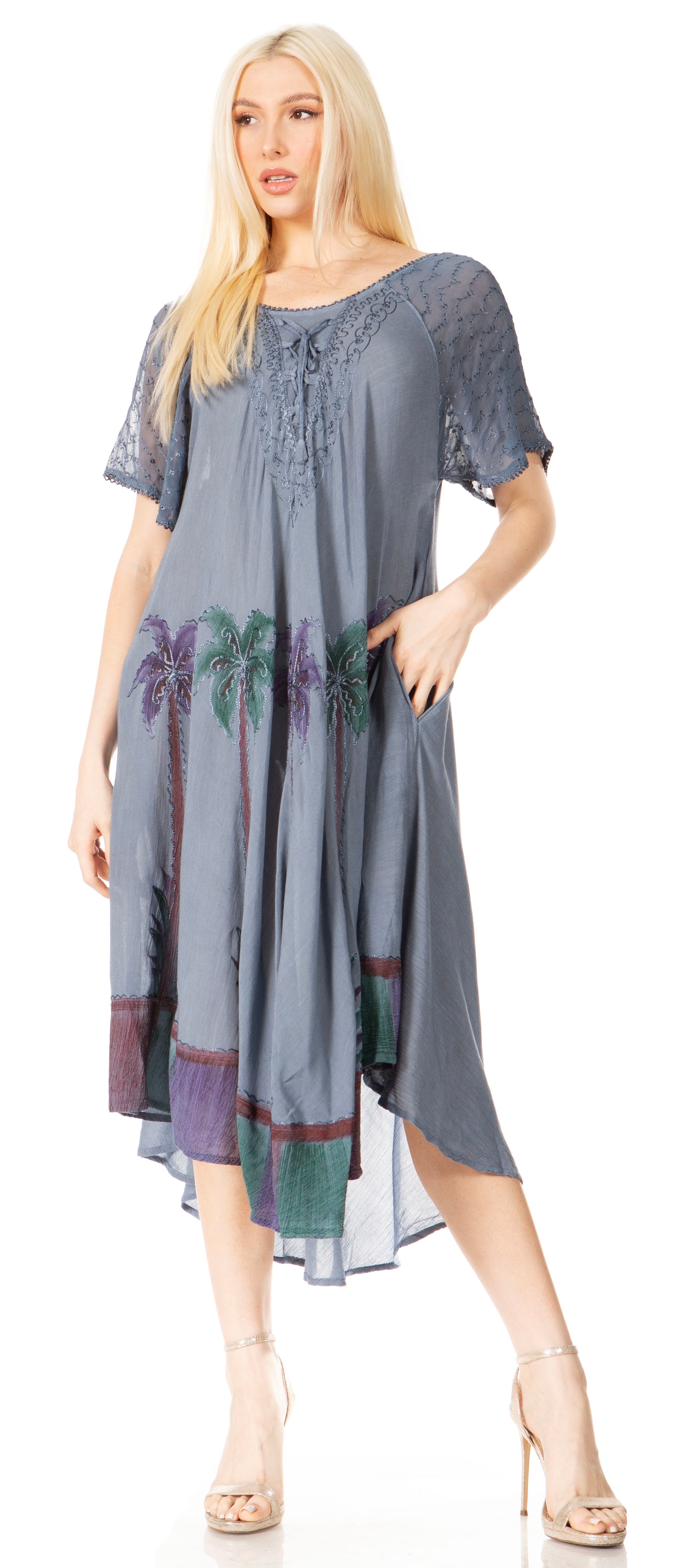 Woman wearing a long, flowing dress with floral patterns on a plain background