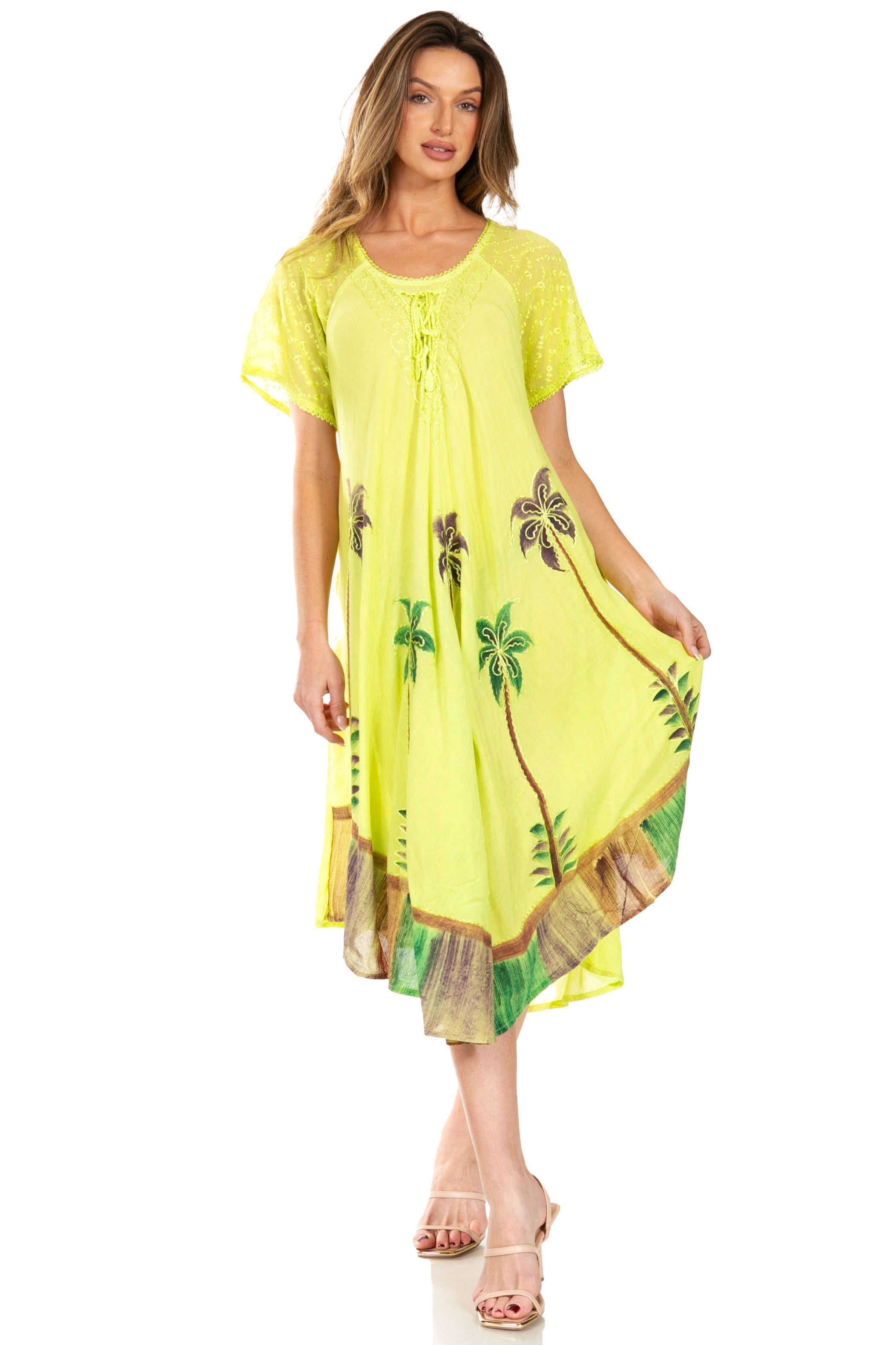 Woman wearing a bright yellow dress with palm tree patterns on a white background