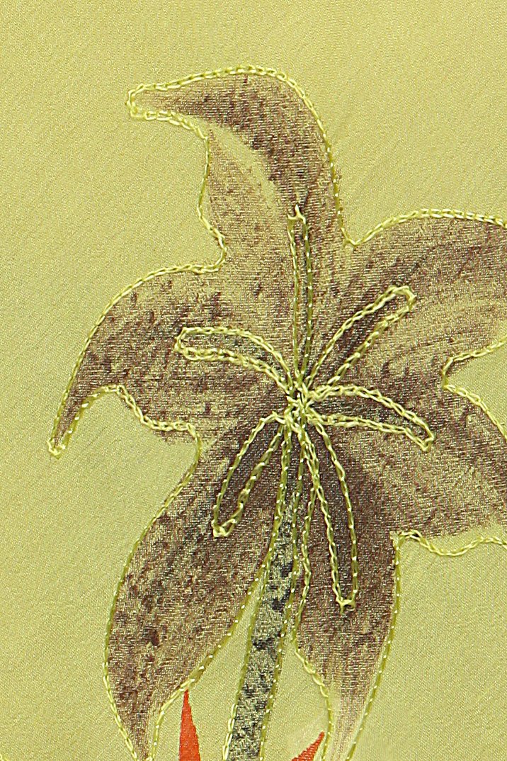 Embroidered flower design on fabric with a green background