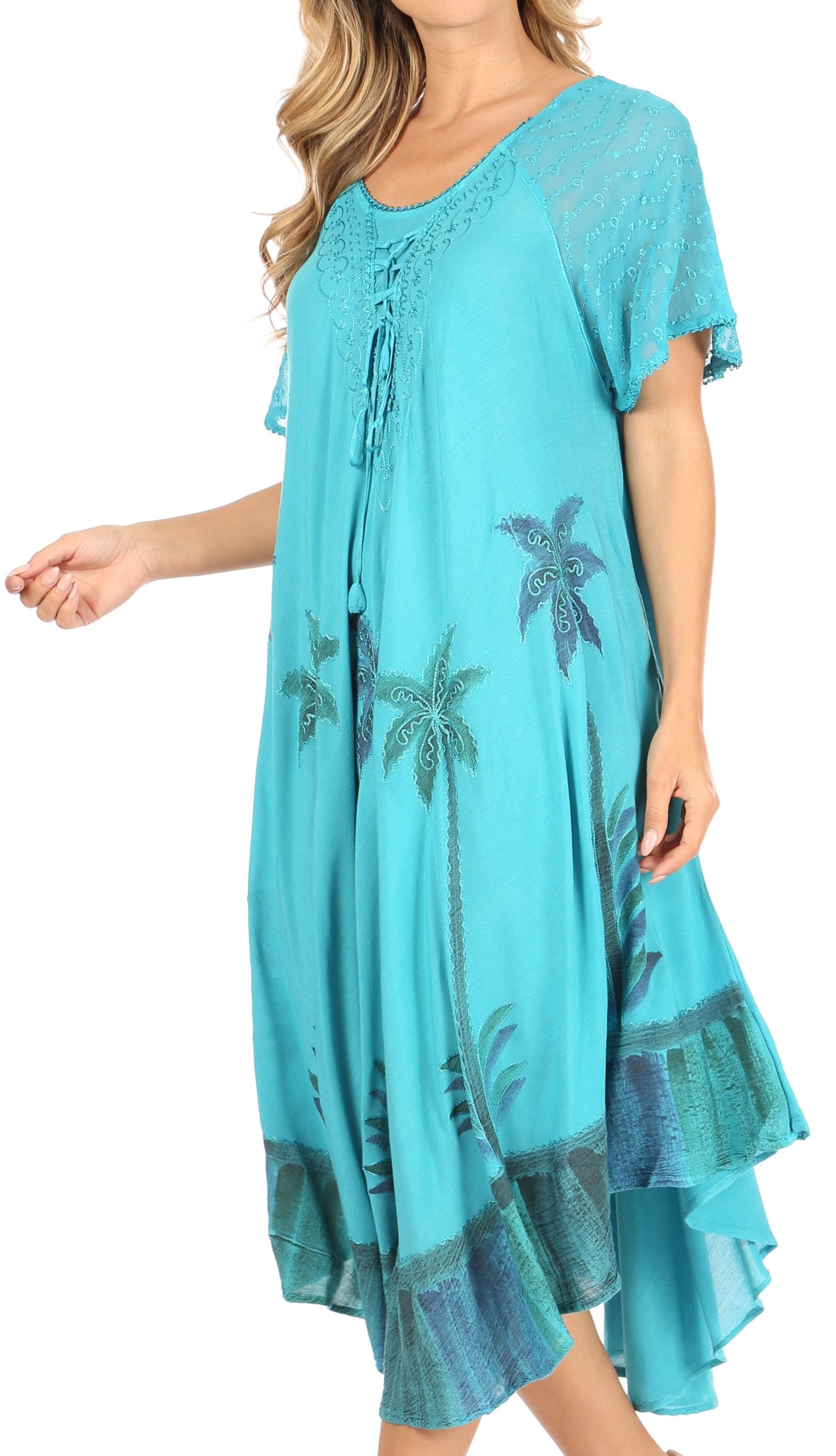 Turquoise dress with palm tree pattern worn by a model on a white background