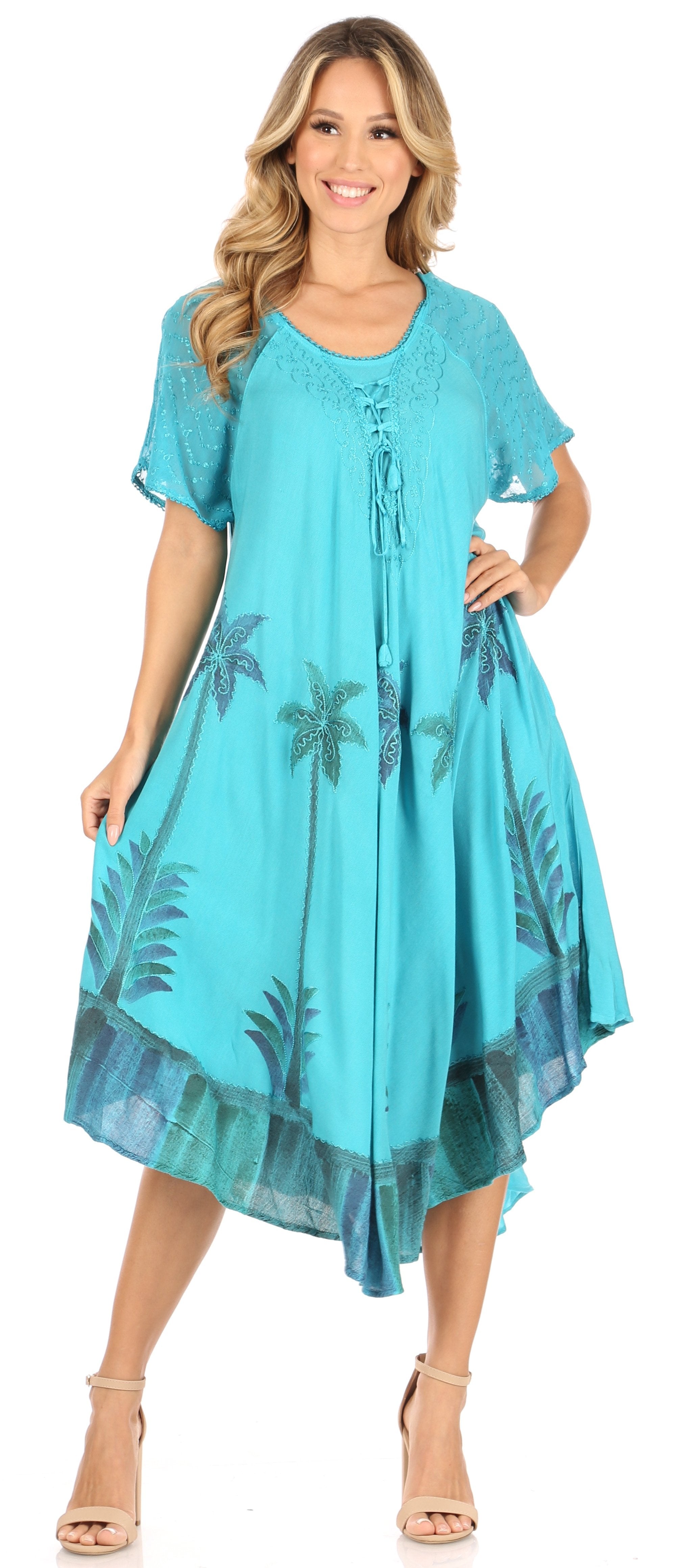 Woman wearing a turquoise dress with palm tree patterns on a white background