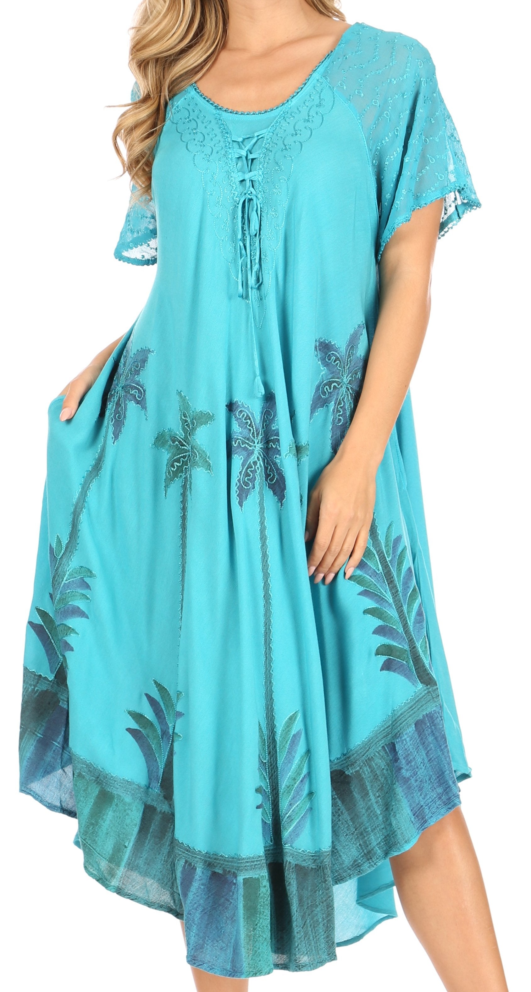 Turquoise dress with palm tree pattern worn by a model on a white background