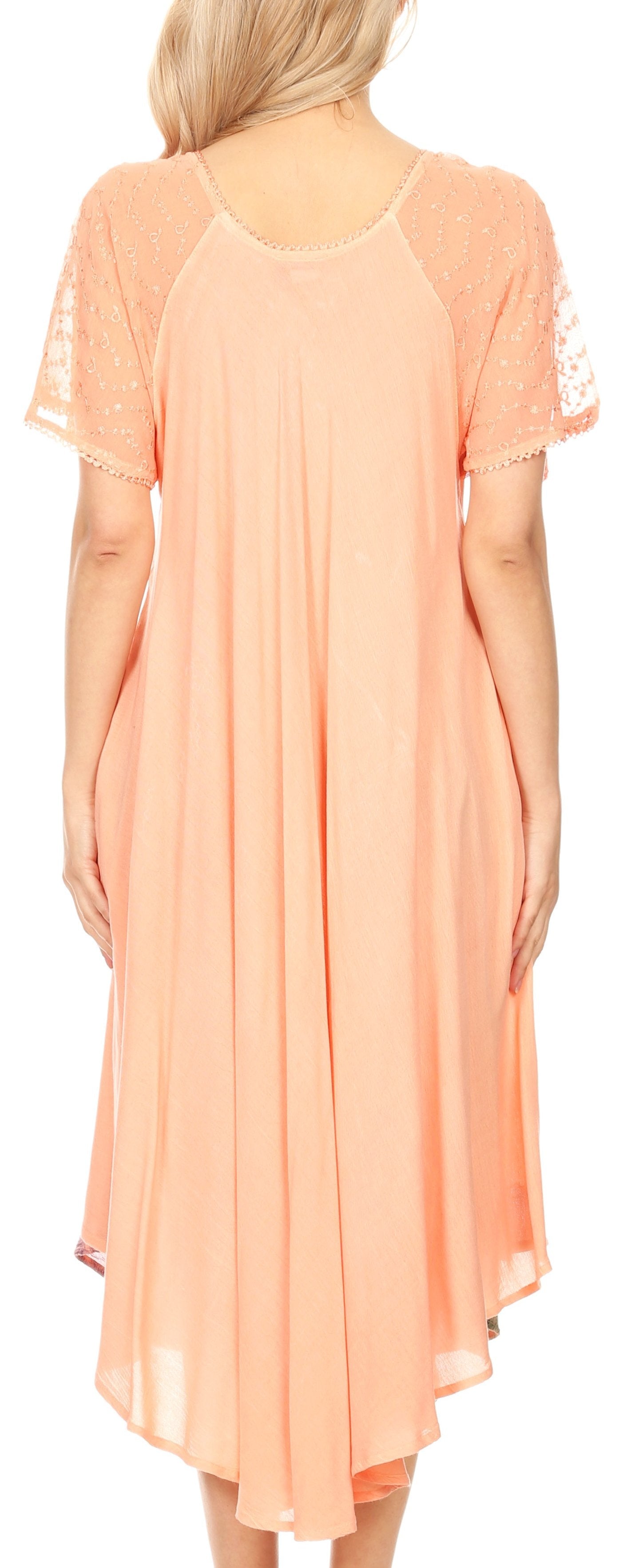Woman wearing a peach-colored dress with lace sleeves and trim.