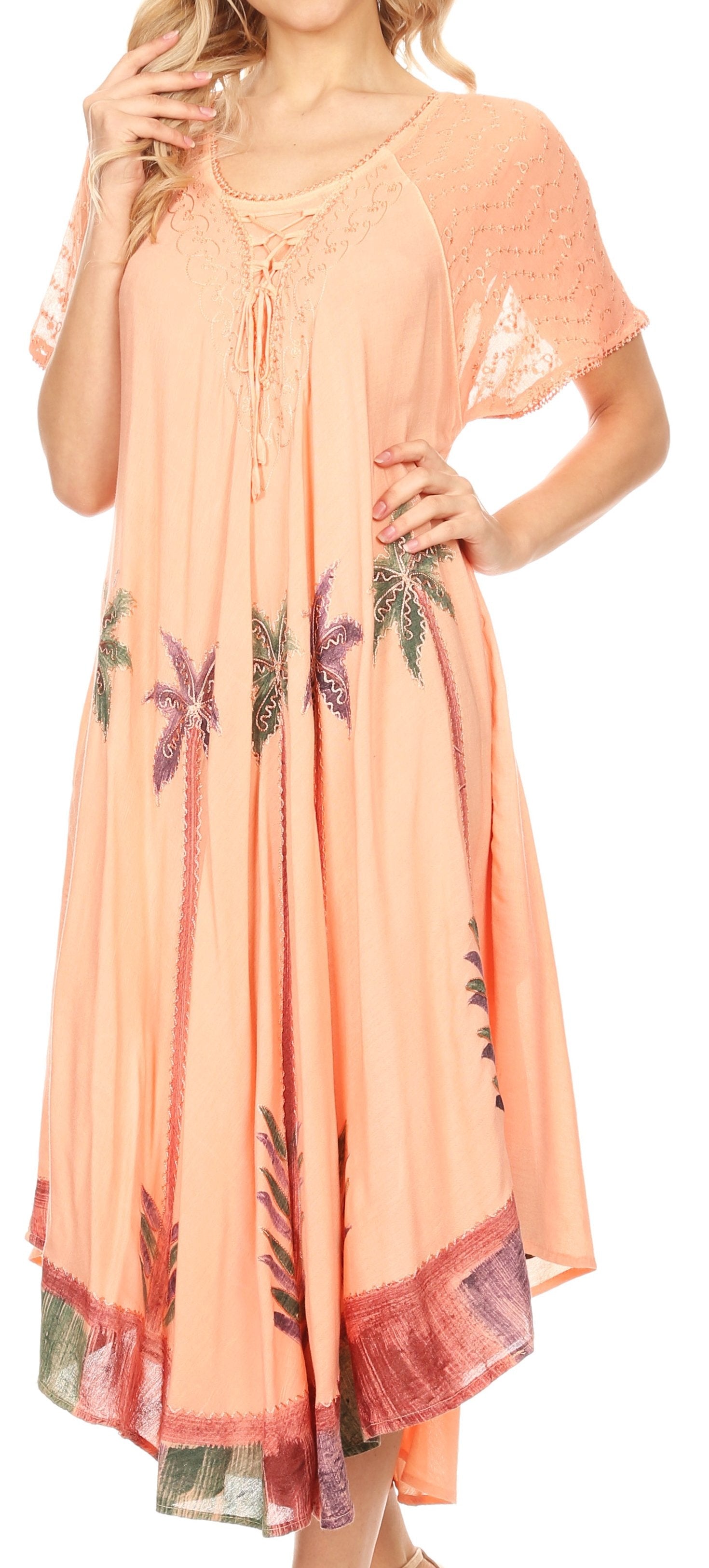 Woman wearing a peach-colored dress with floral patterns, standing against a neutral background.