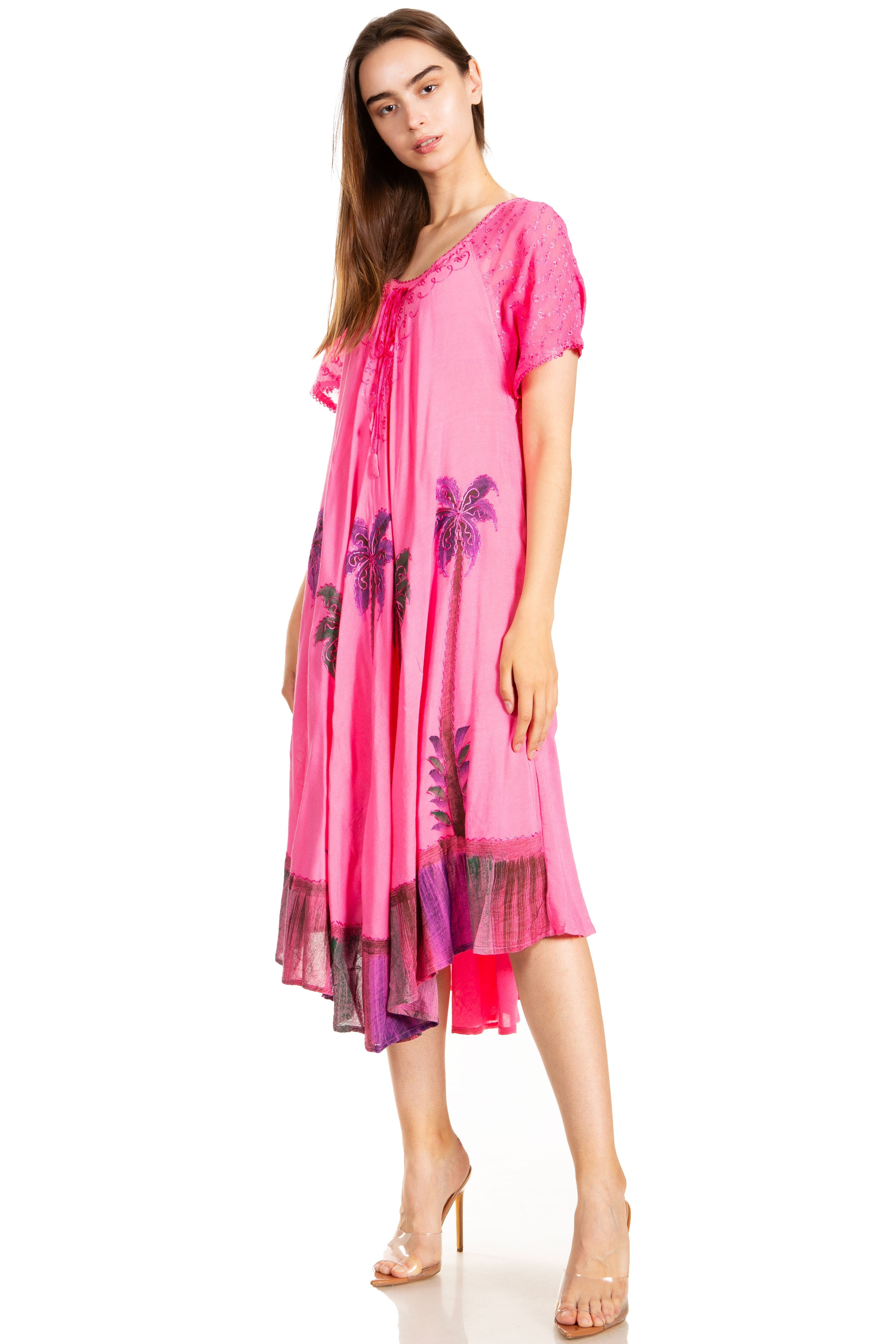Woman wearing a pink dress with floral patterns on a white background