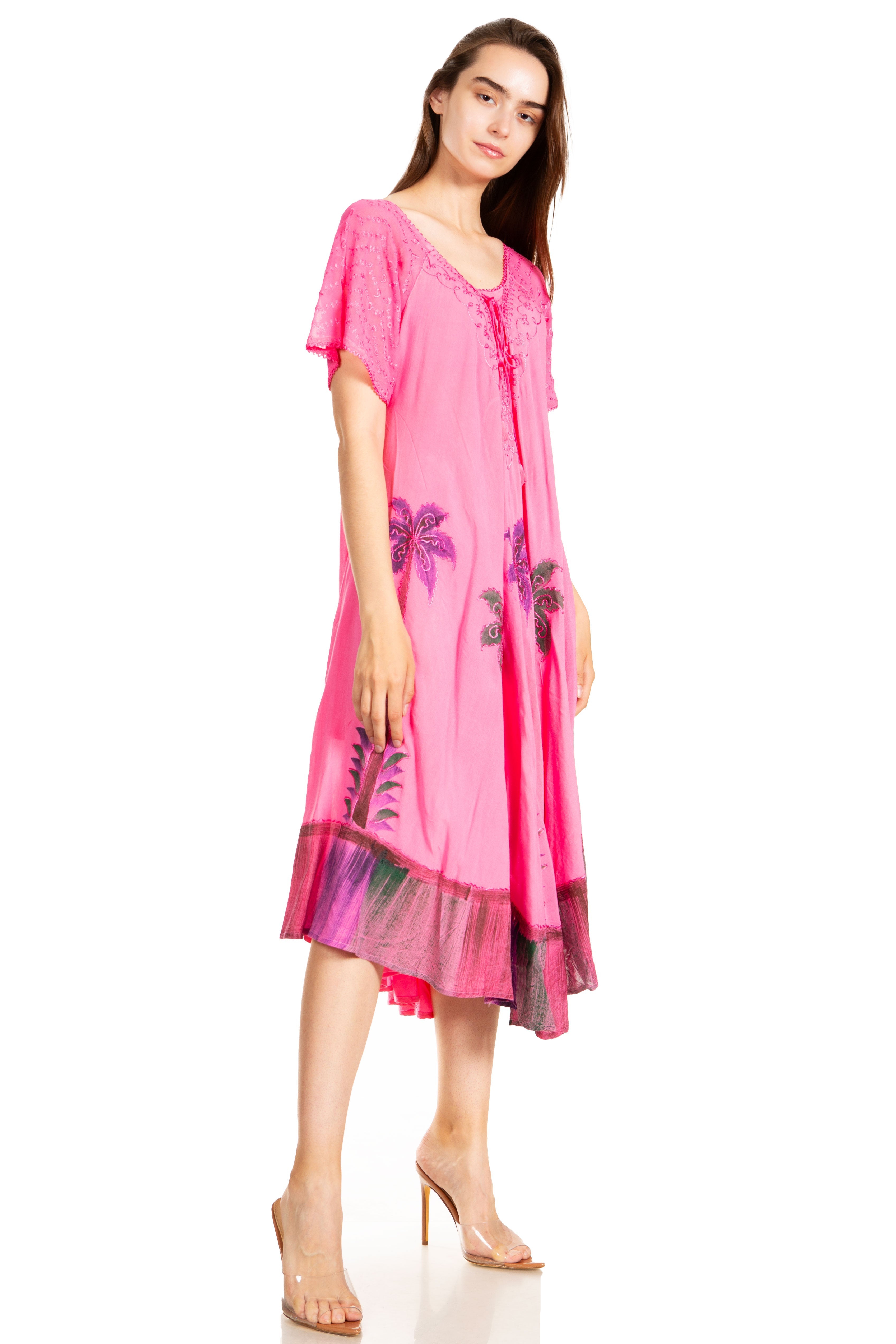 Woman wearing a pink dress with floral patterns on a white background
