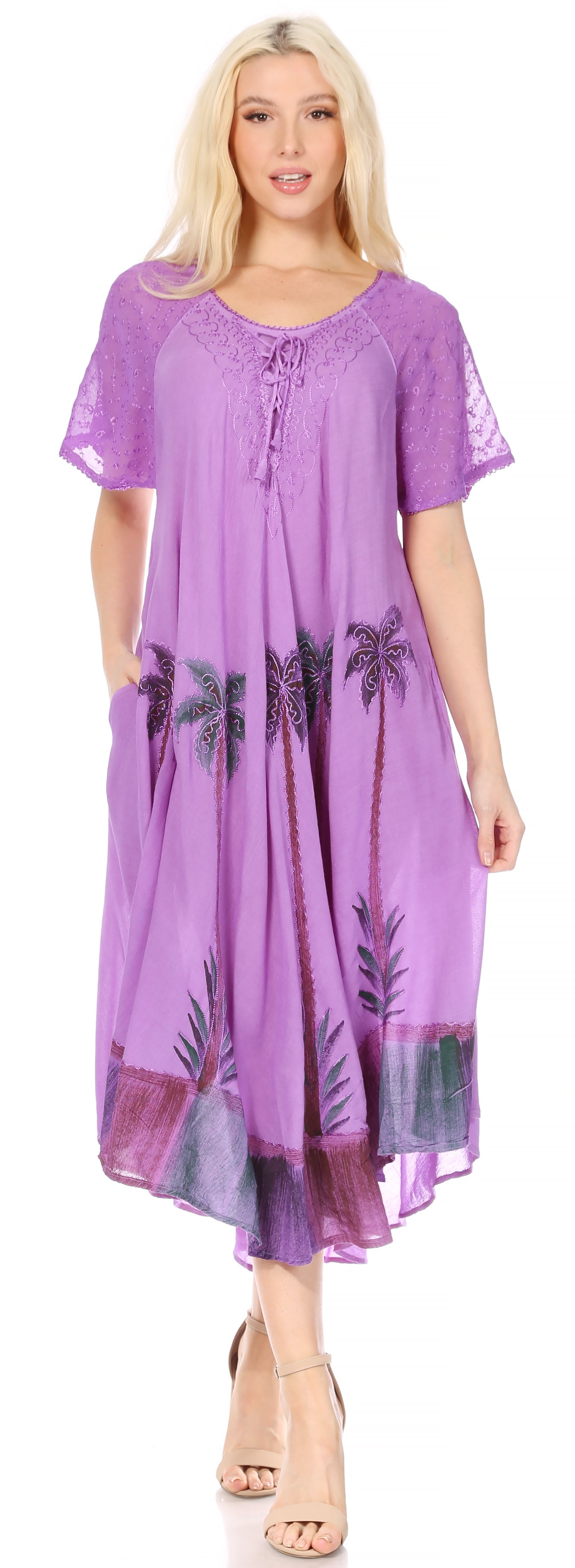 Woman wearing a purple dress with palm tree patterns on a plain background