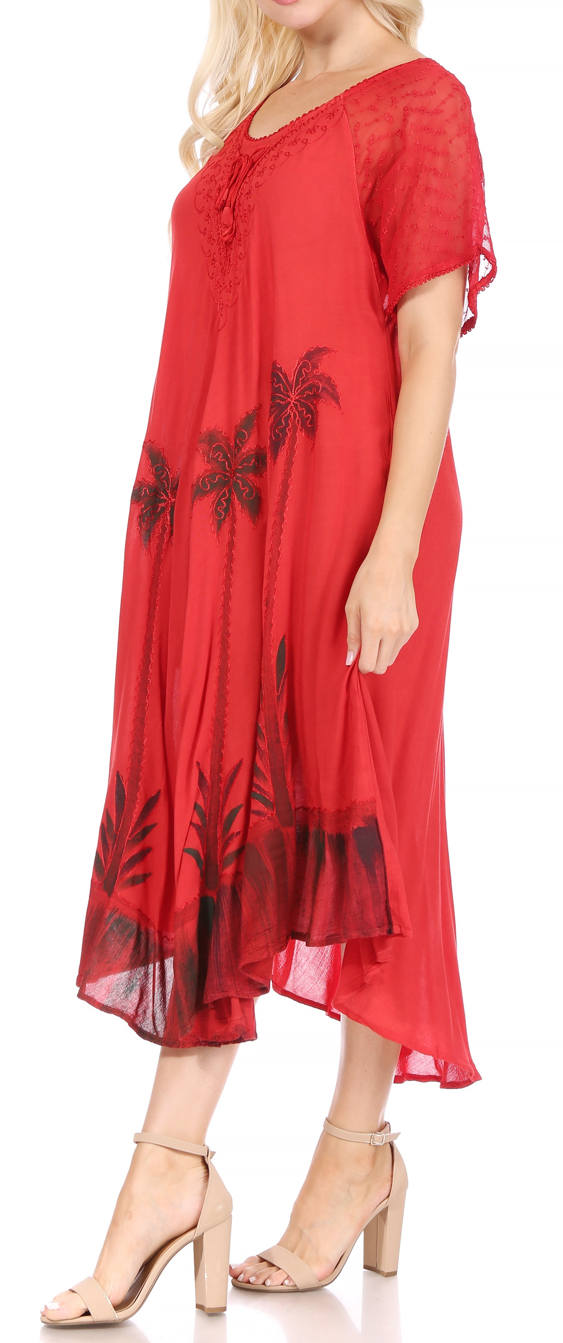 Red dress with black floral embroidery worn by a model on a white background