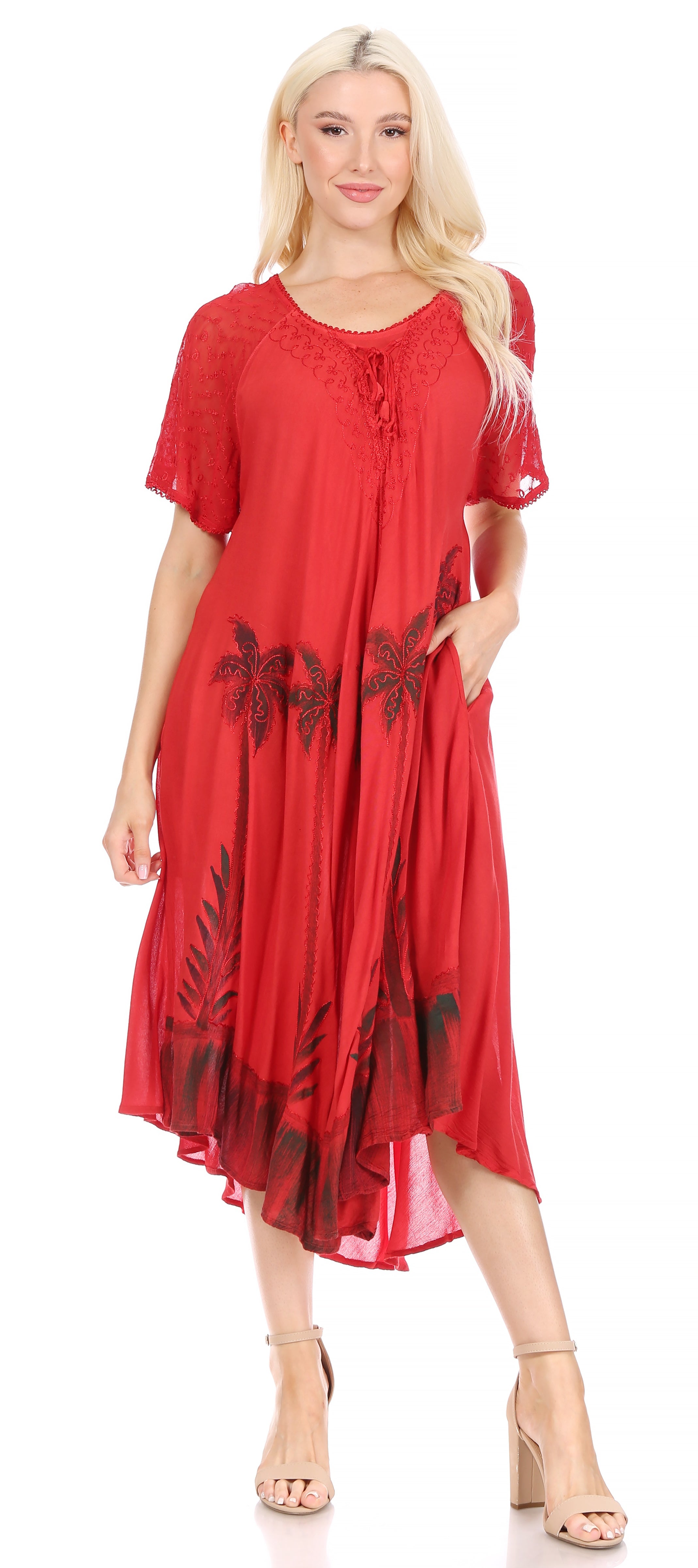 Woman wearing a red dress with black leaf patterns on a white background
