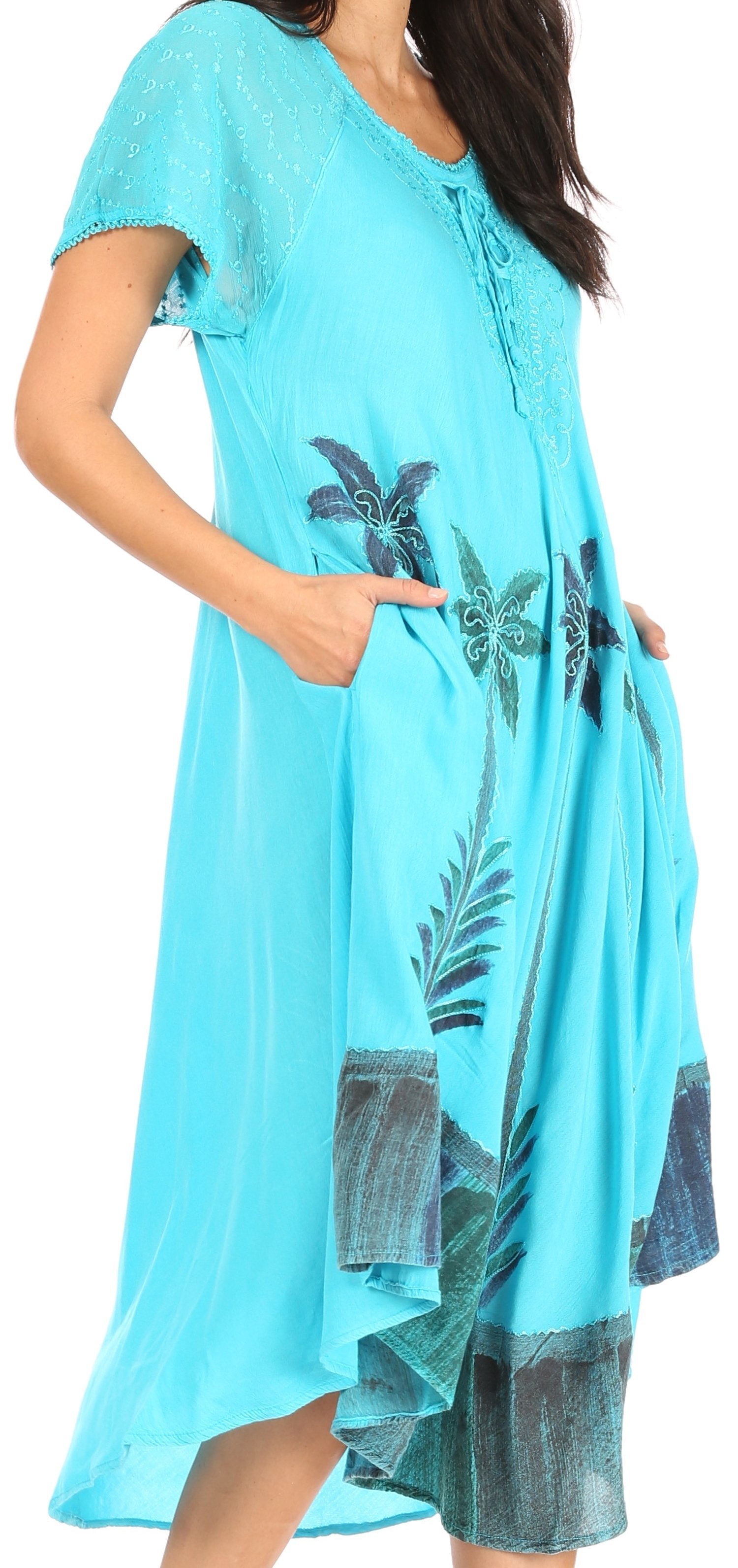 Woman wearing a turquoise dress with floral patterns on a white background