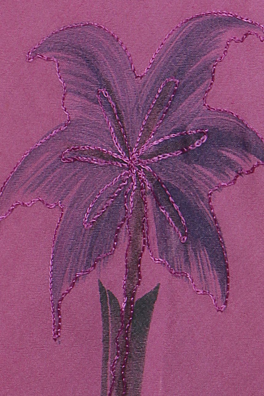 Embroidered flower design on a purple fabric background