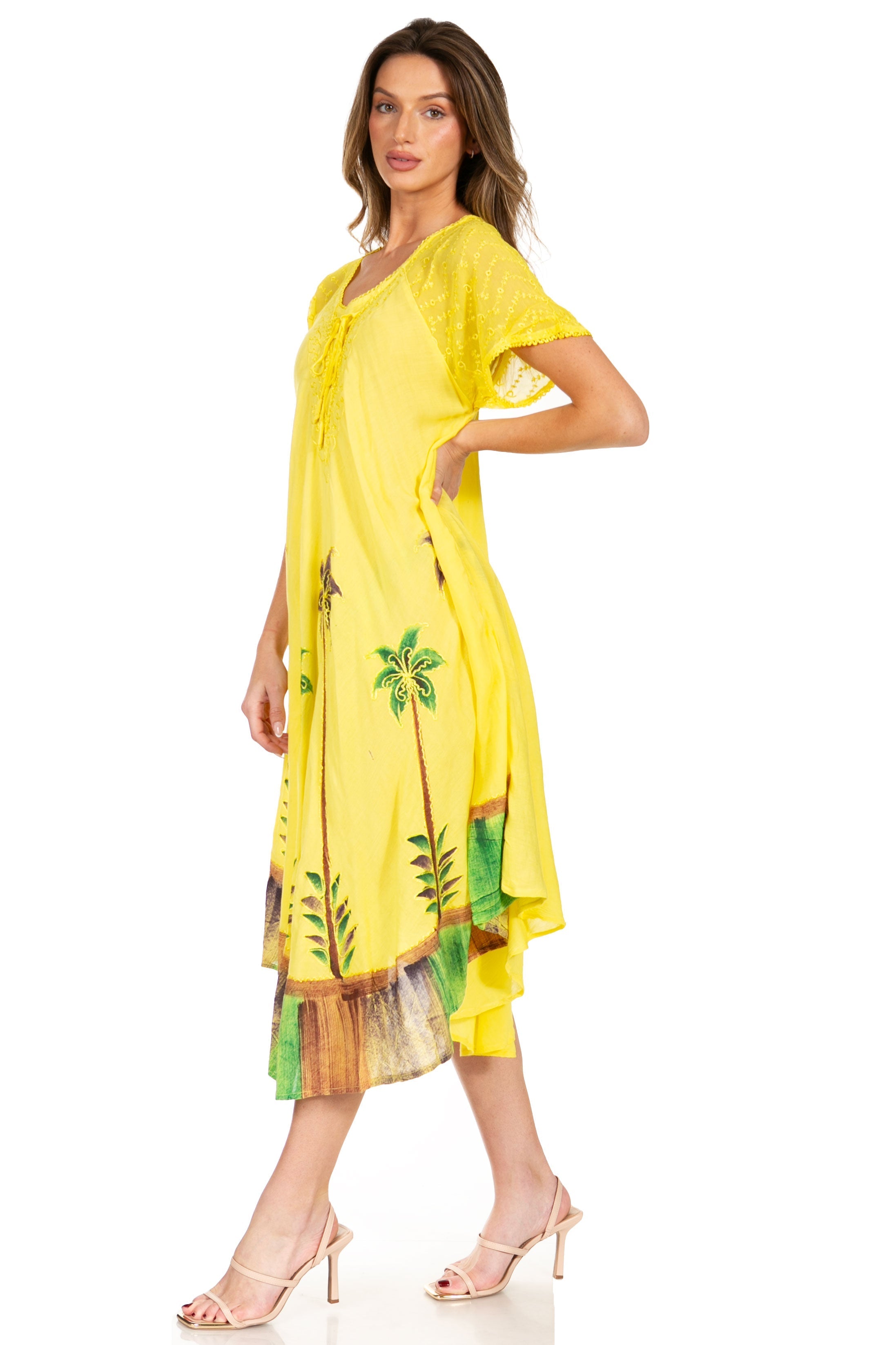 Woman wearing a yellow dress with palm tree design on a white background