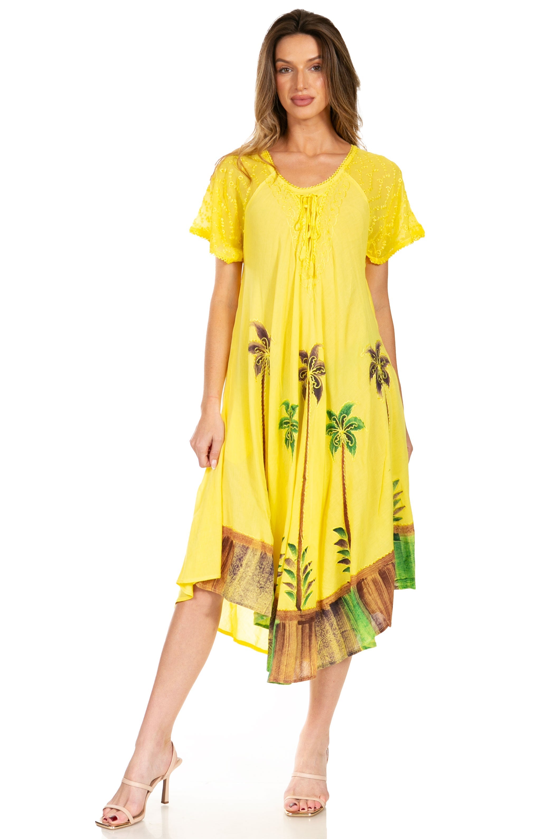 Woman wearing a yellow dress with palm tree designs on a white background