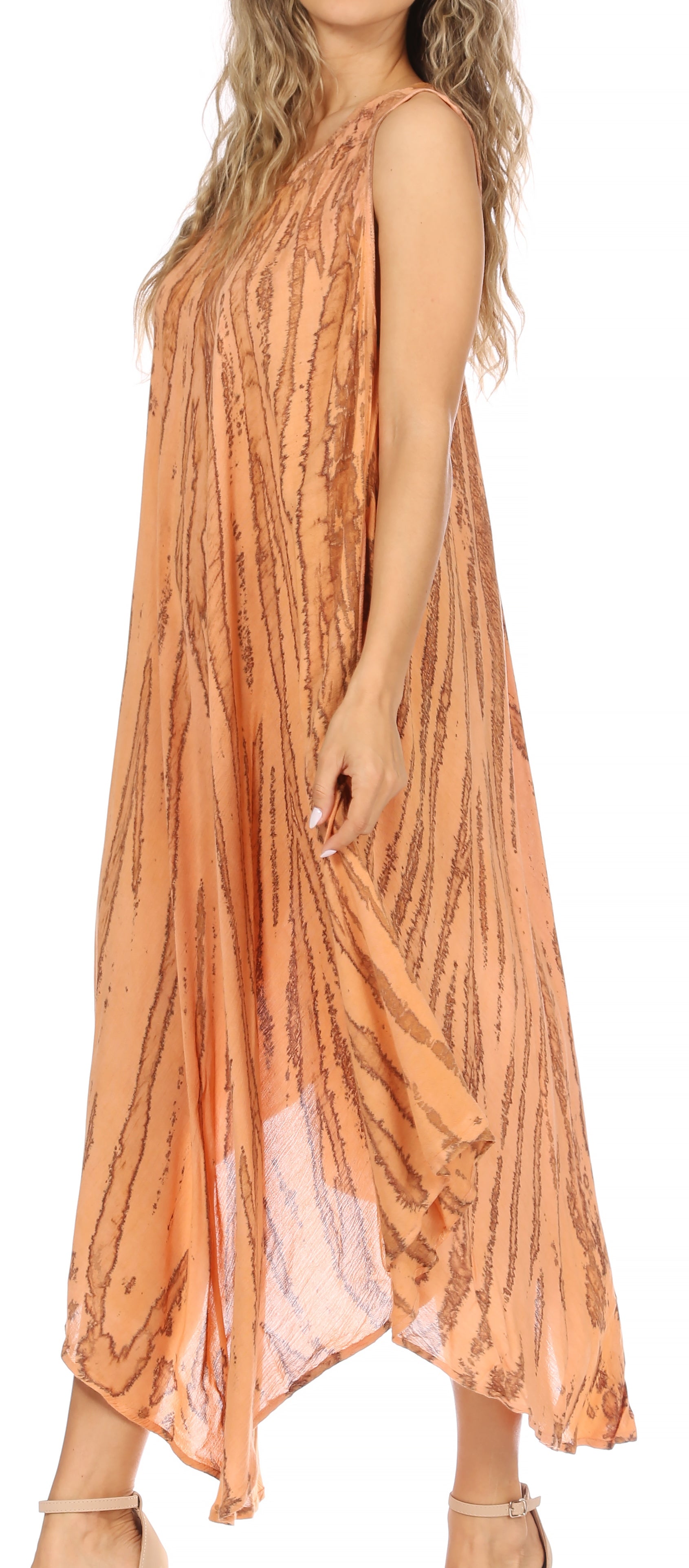 Woman wearing a long, flowing dress with a subtle pattern on a plain background