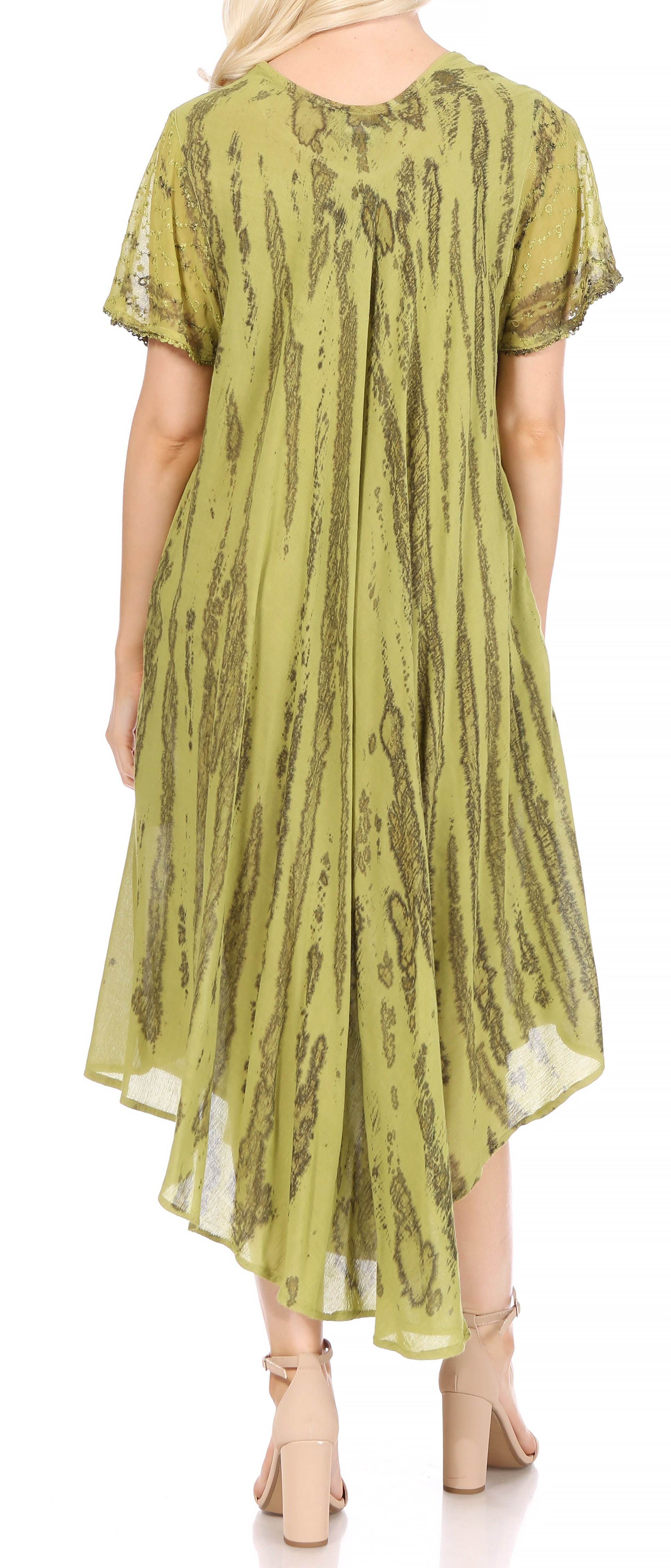 Woman wearing a green patterned dress with beige heels on a white background