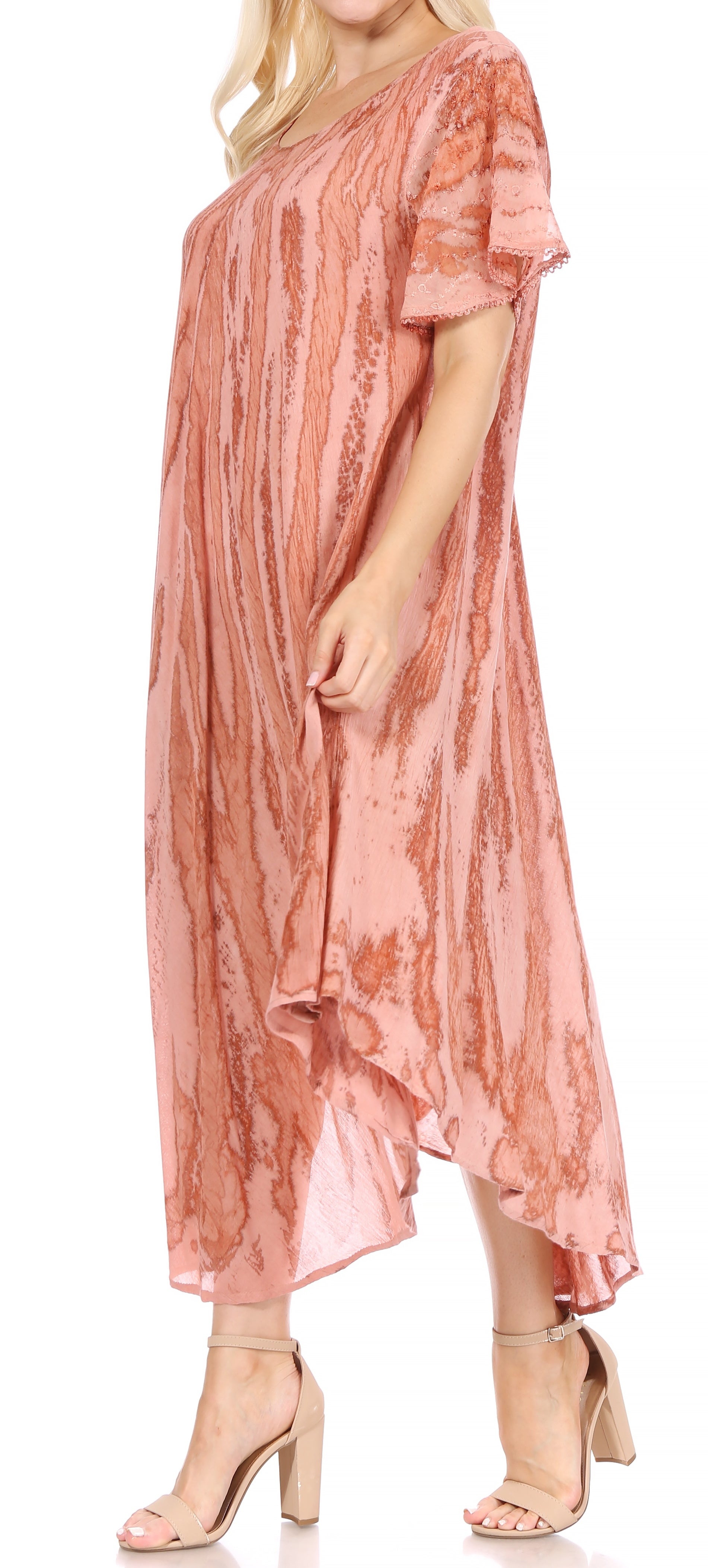 Woman wearing a pink patterned dress with beige sandals on a white background