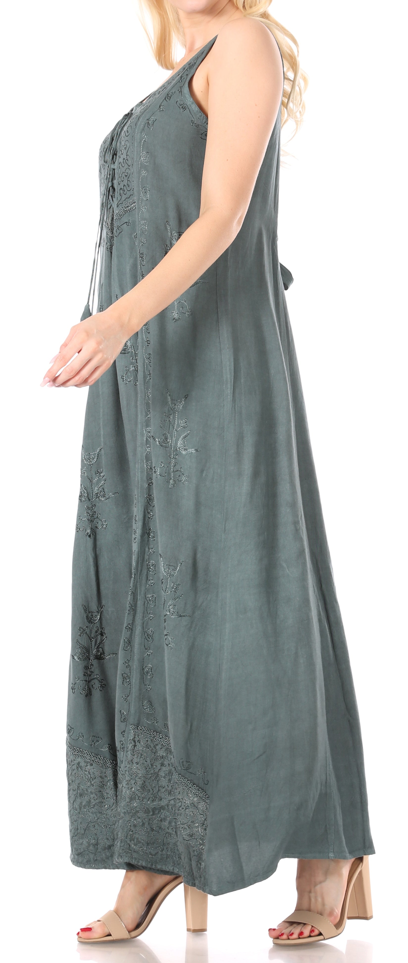 Woman wearing a sleeveless green dress with lace details on a white background