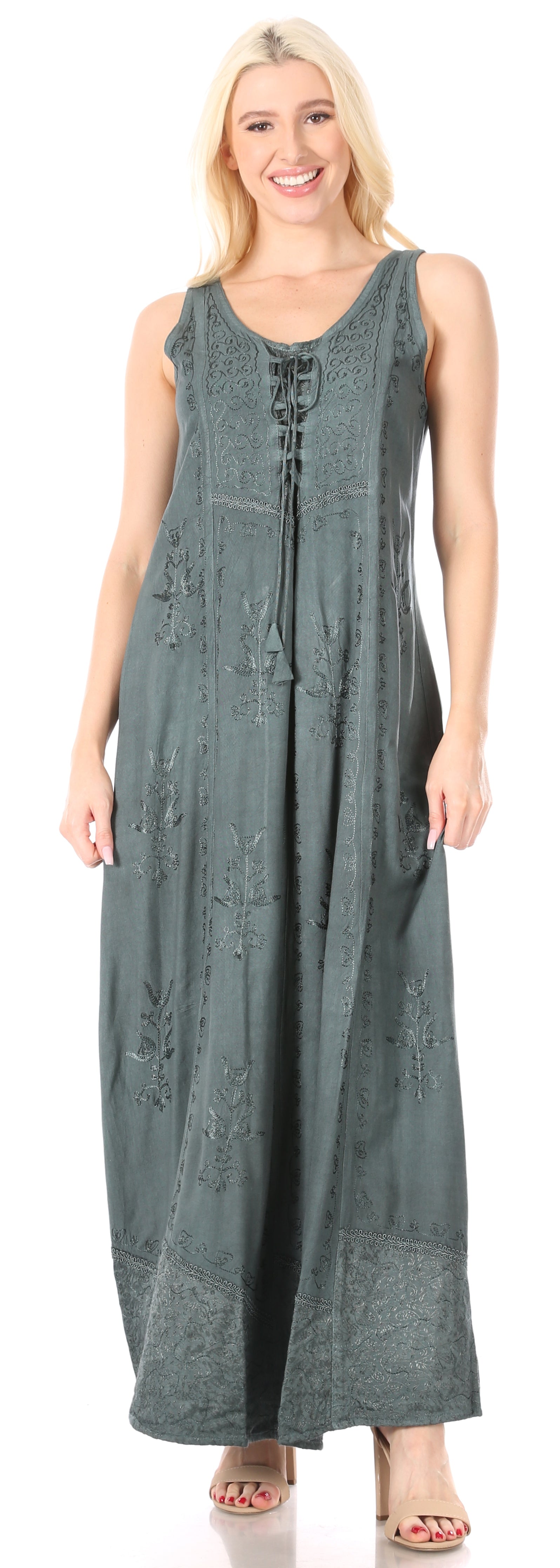 Woman wearing a long sleeveless dress with lace details on a white background