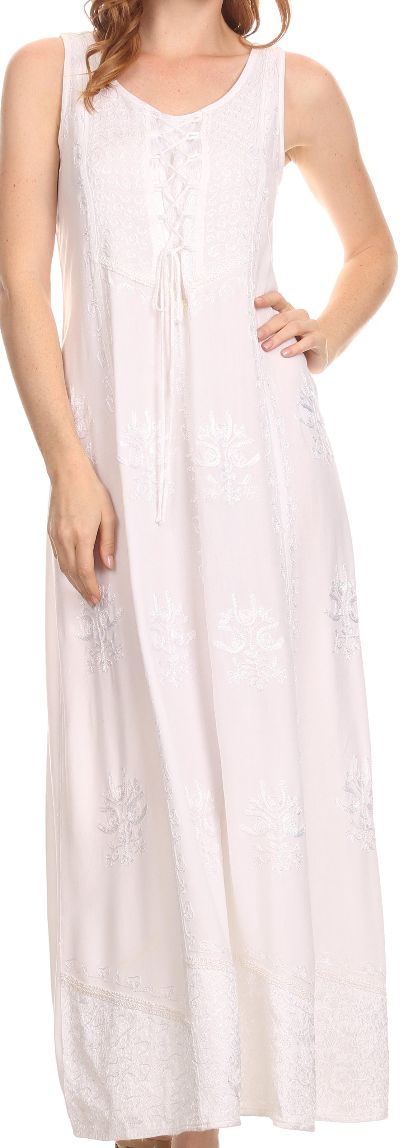 Woman wearing a white sleeveless dress with buttons, standing against a neutral background.