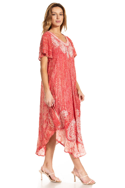 Woman wearing a coral pink dress with lace details on a white background