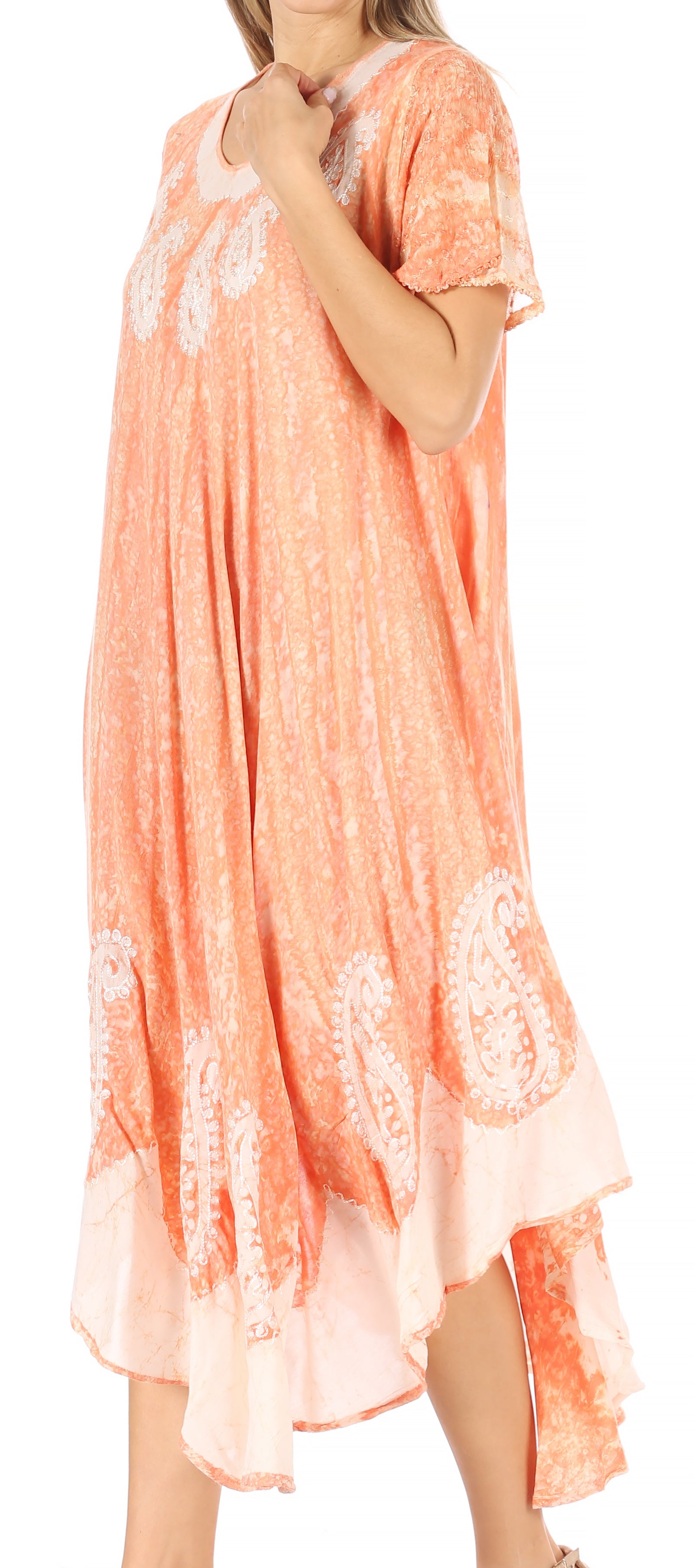 Woman wearing a peach-colored dress with lace details on a white background