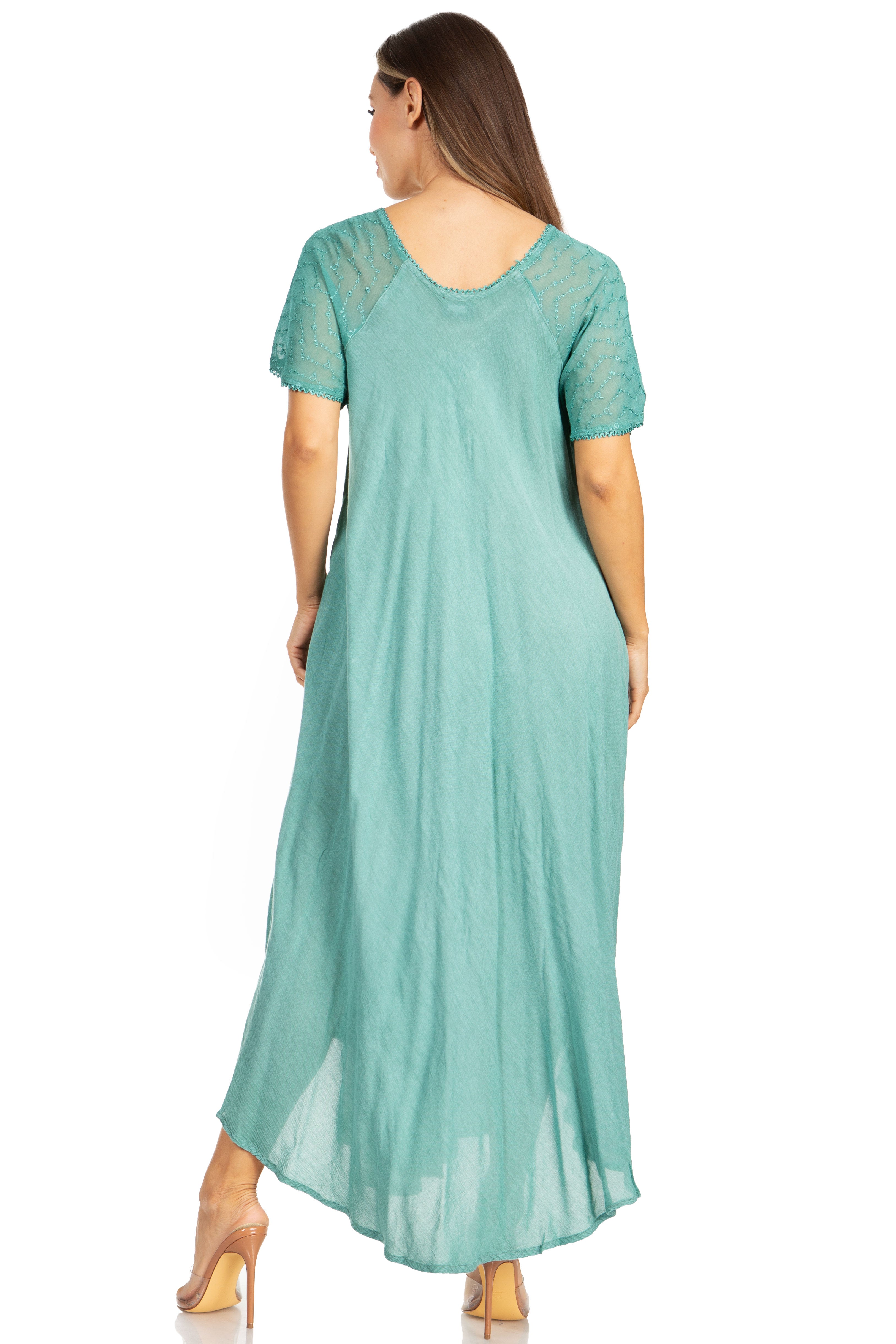 Woman wearing a teal dress with sheer sleeves on a white background