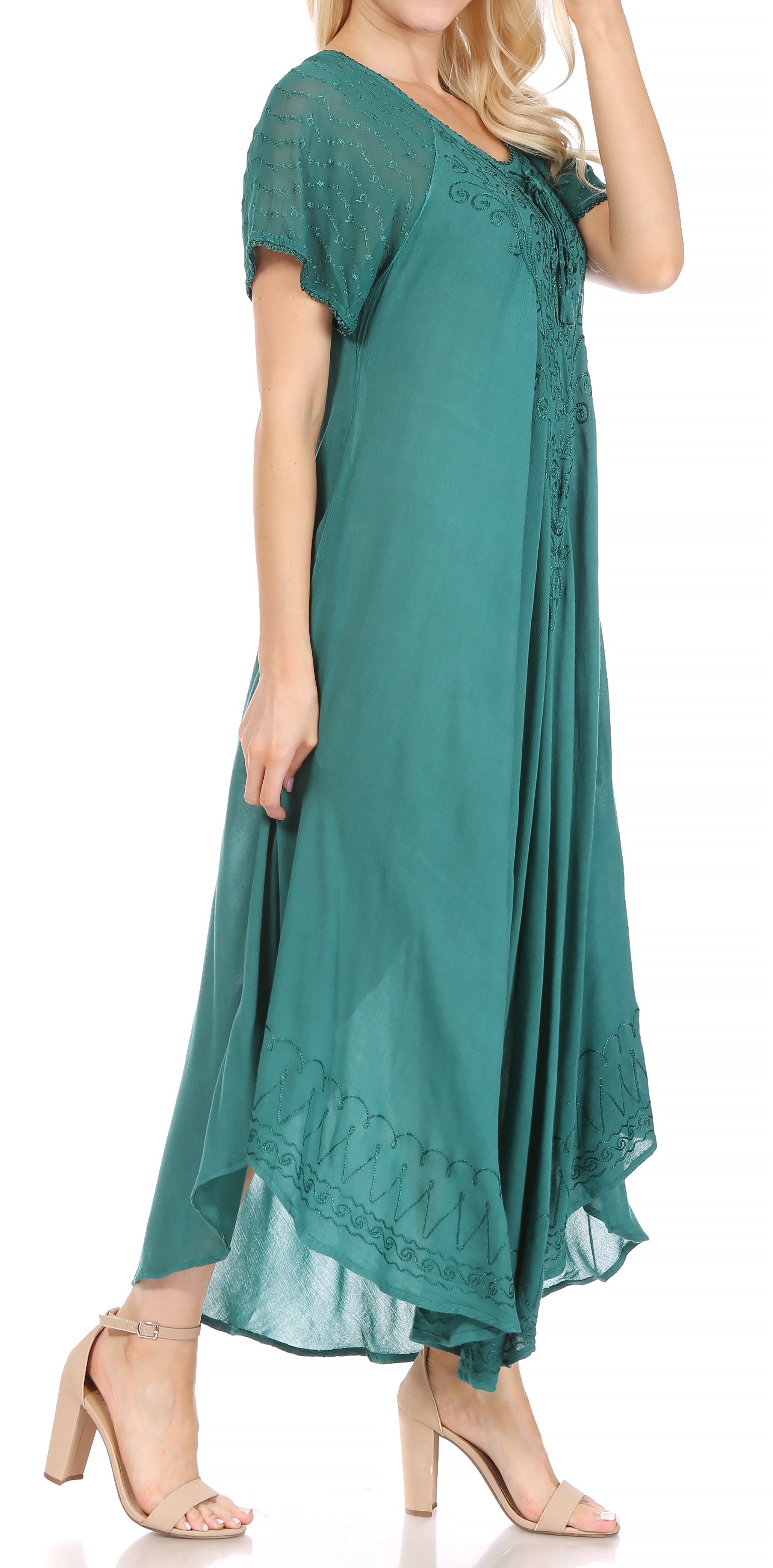 Woman wearing a teal dress with lace details on a white background