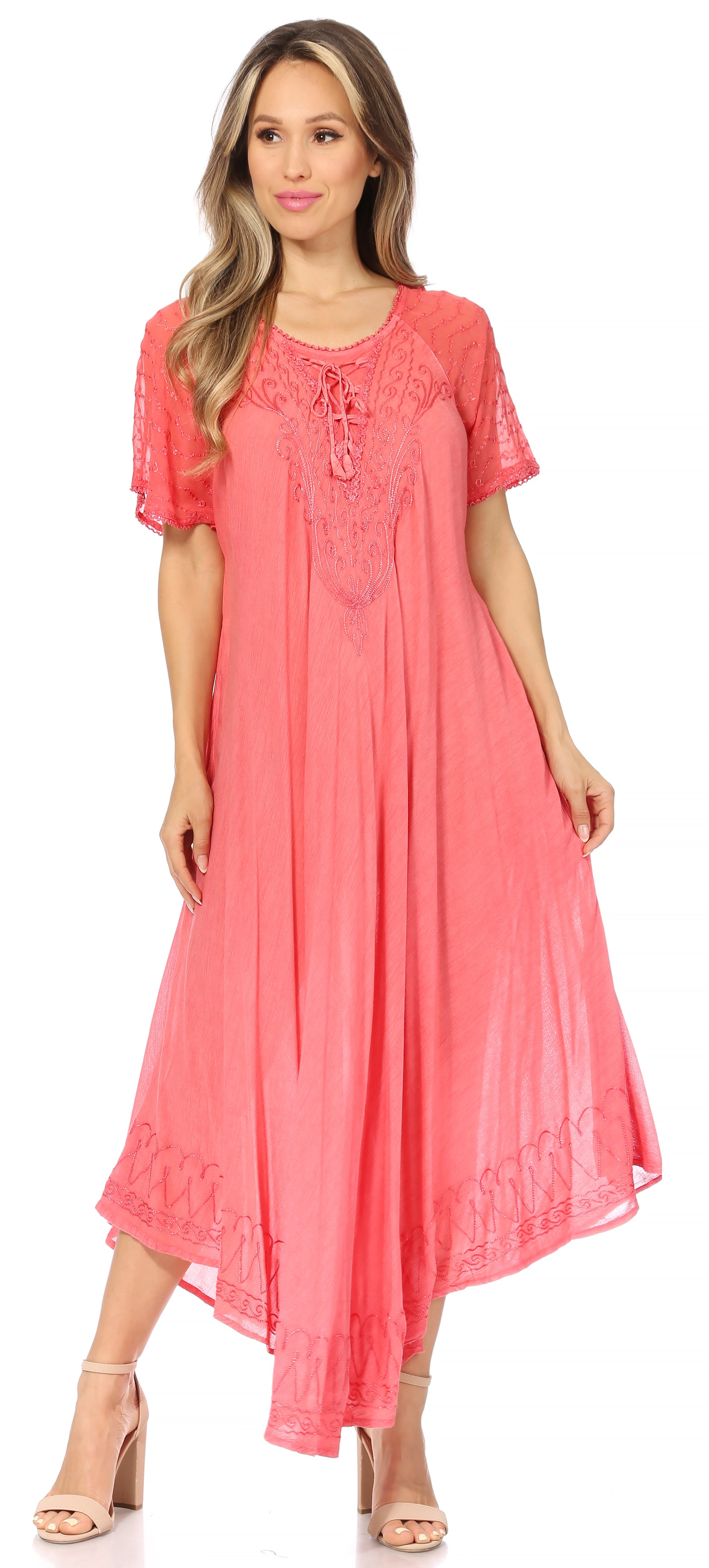 Woman wearing a coral pink dress with lace details on a white background