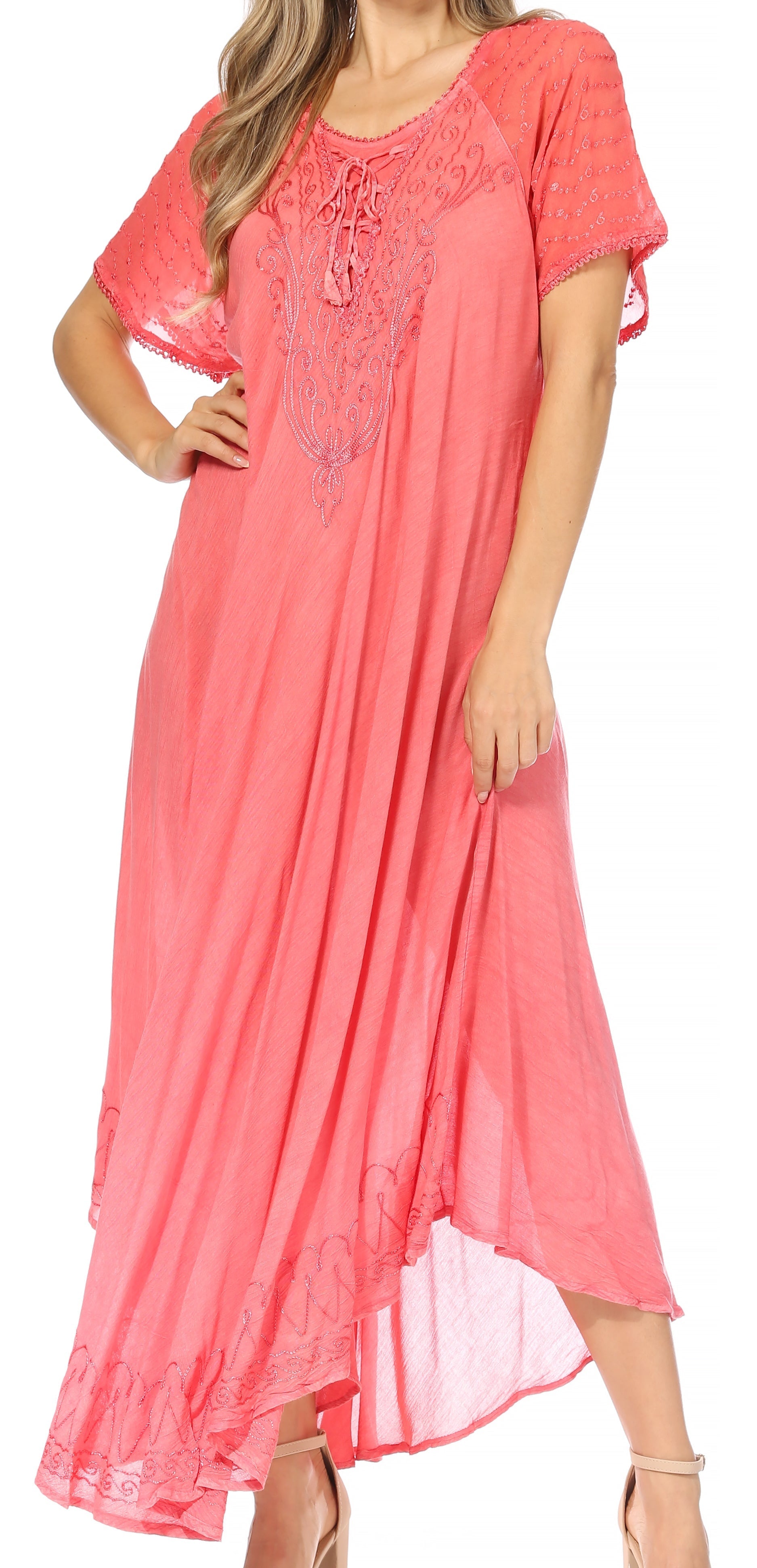 Woman wearing a coral pink dress with lace details on a white background