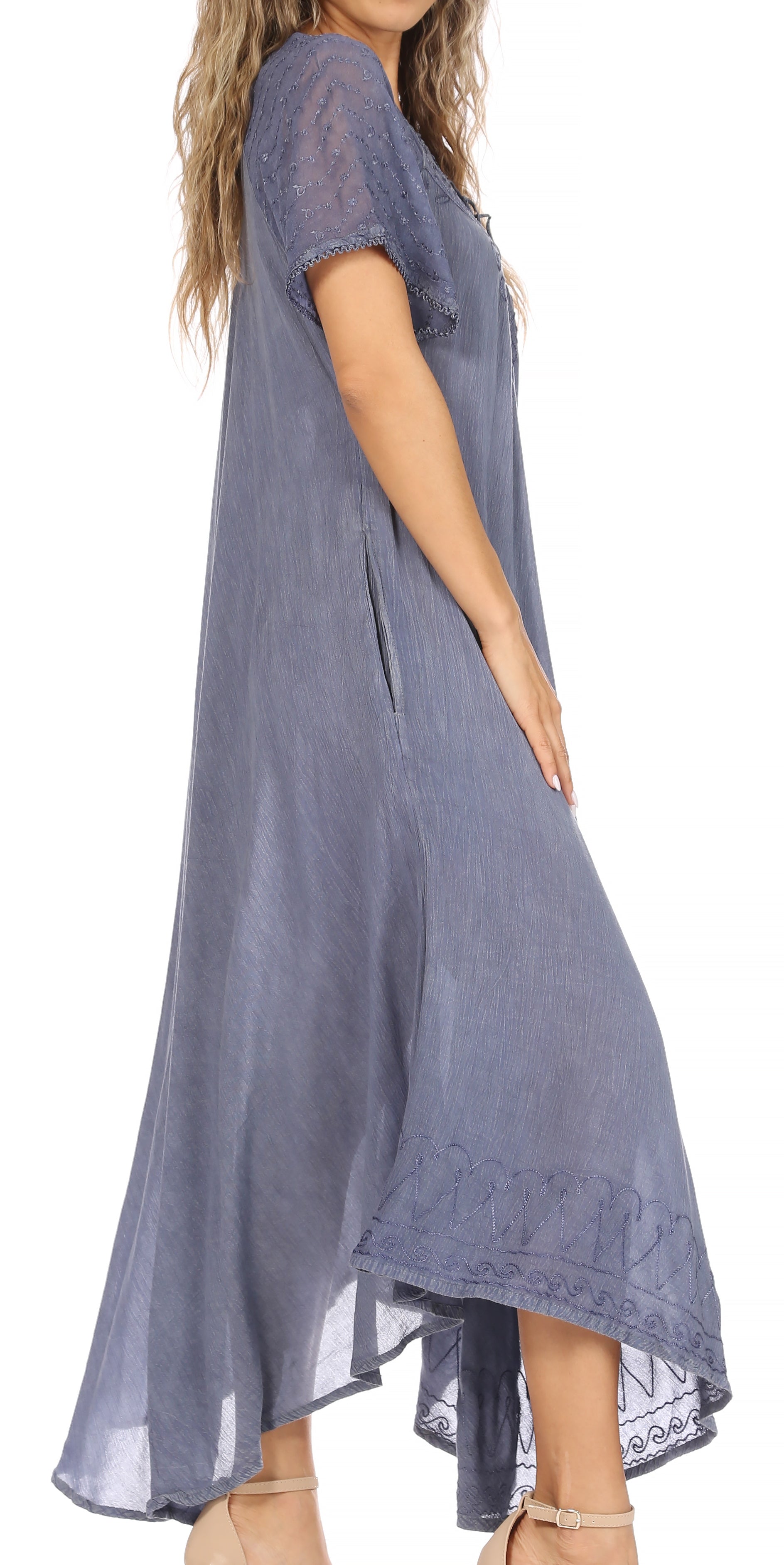 Woman wearing a long, light blue dress with lace details on a white background