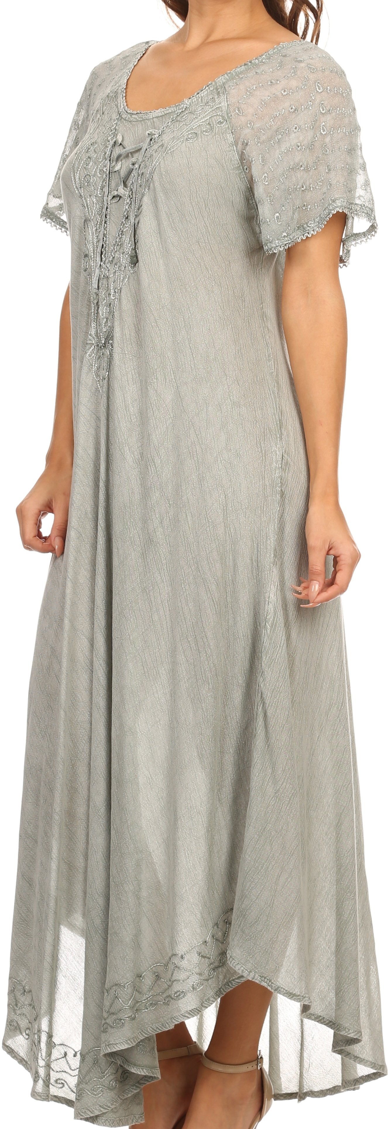 Woman wearing a light gray lace dress with a flowing design.