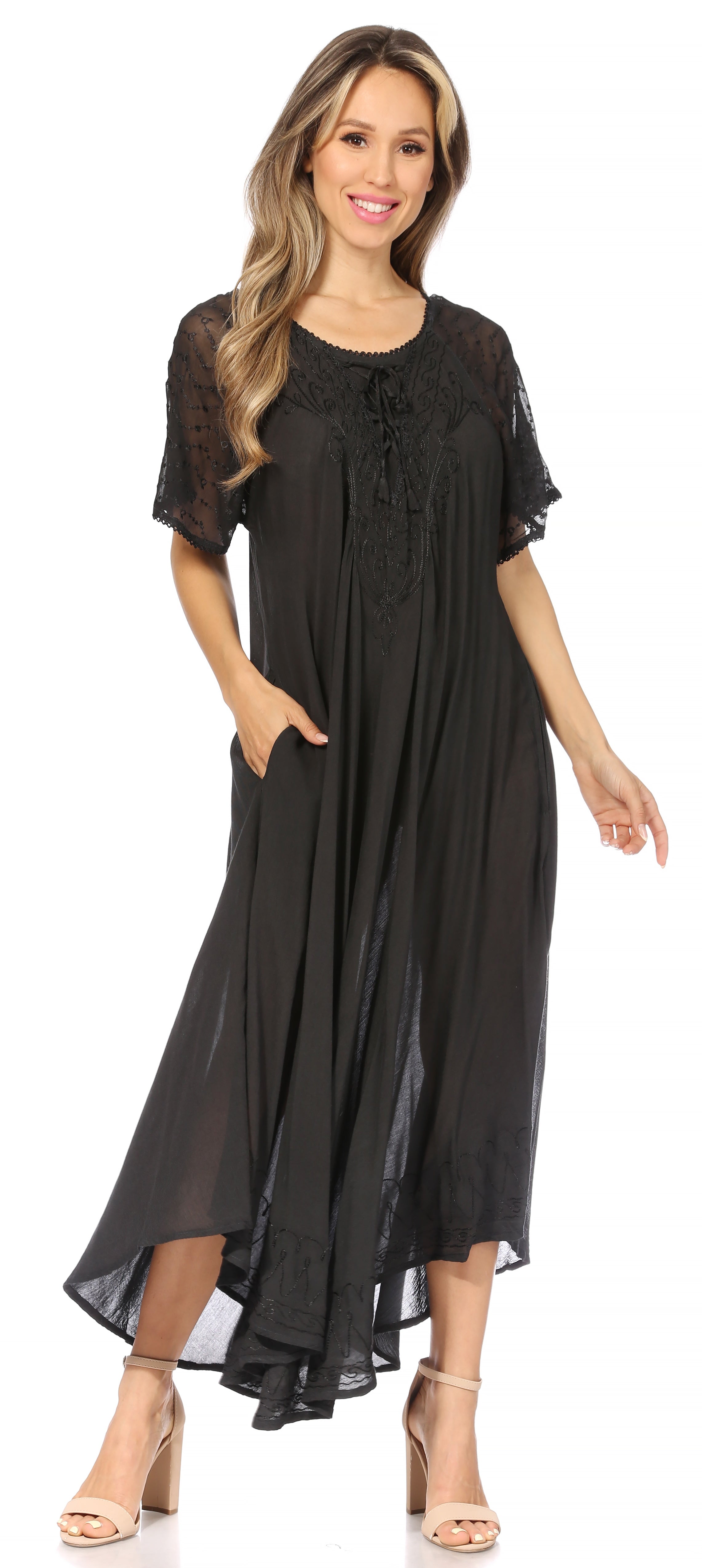 Woman wearing a black dress with sheer sleeves on a white background