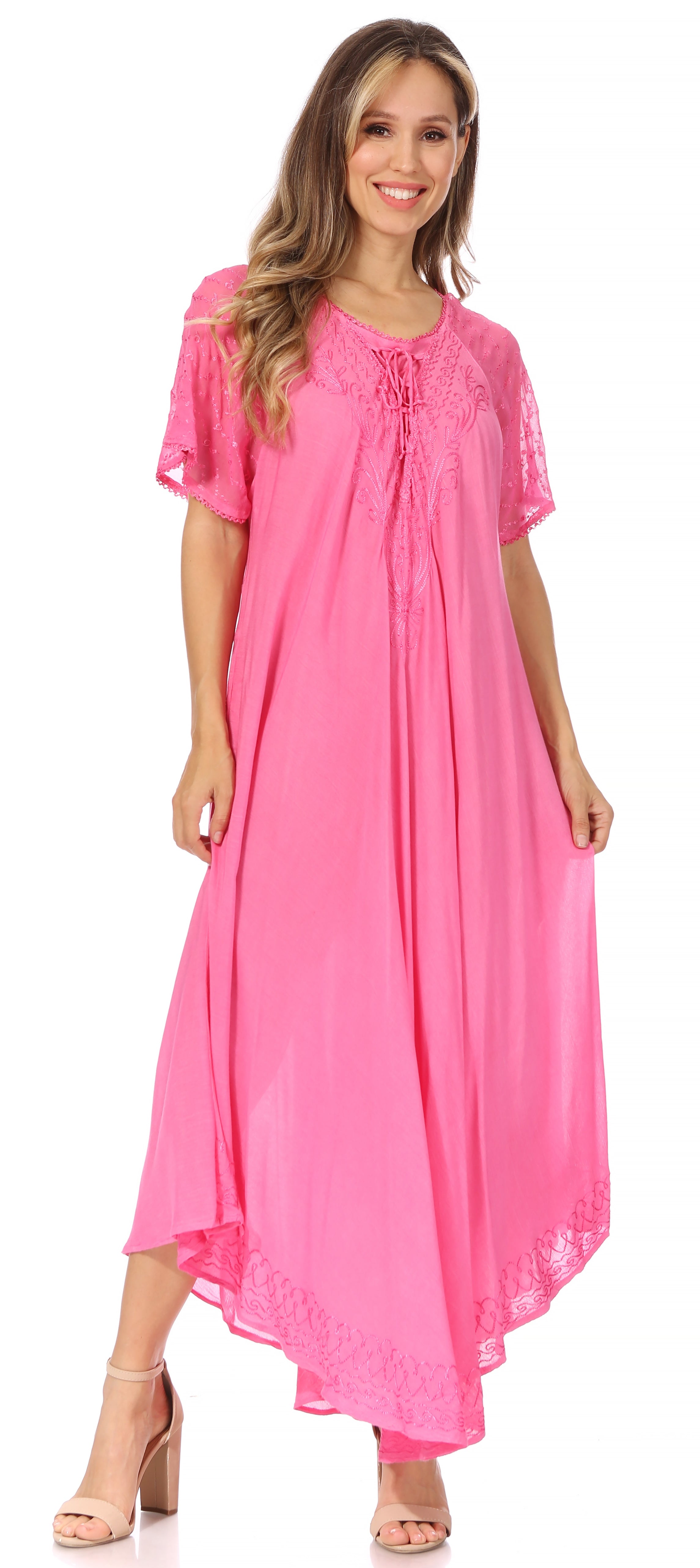 Woman wearing a pink dress with lace details on a white background