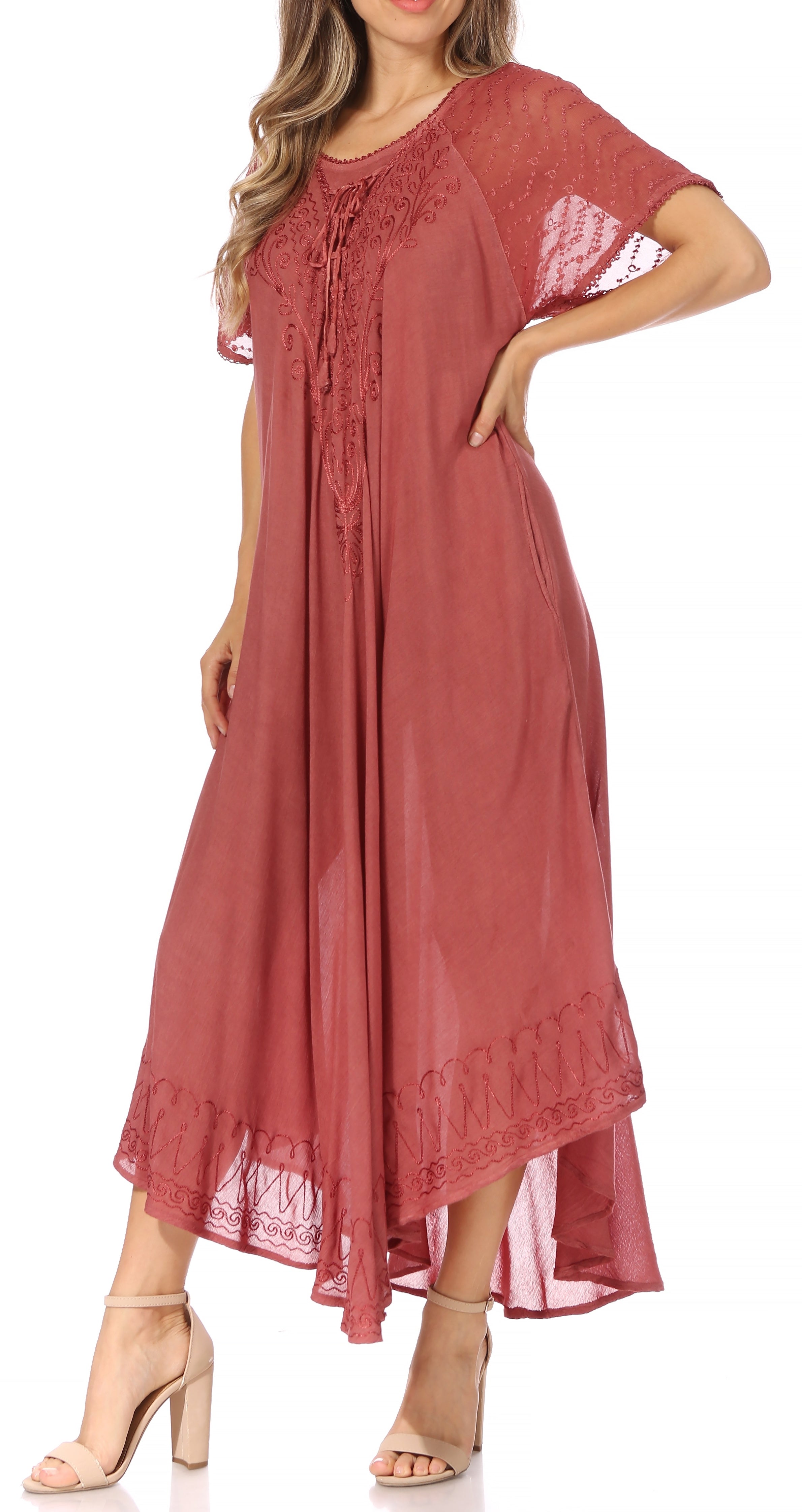 Woman wearing a long, flowing rust-colored dress with lace sleeves on a white background