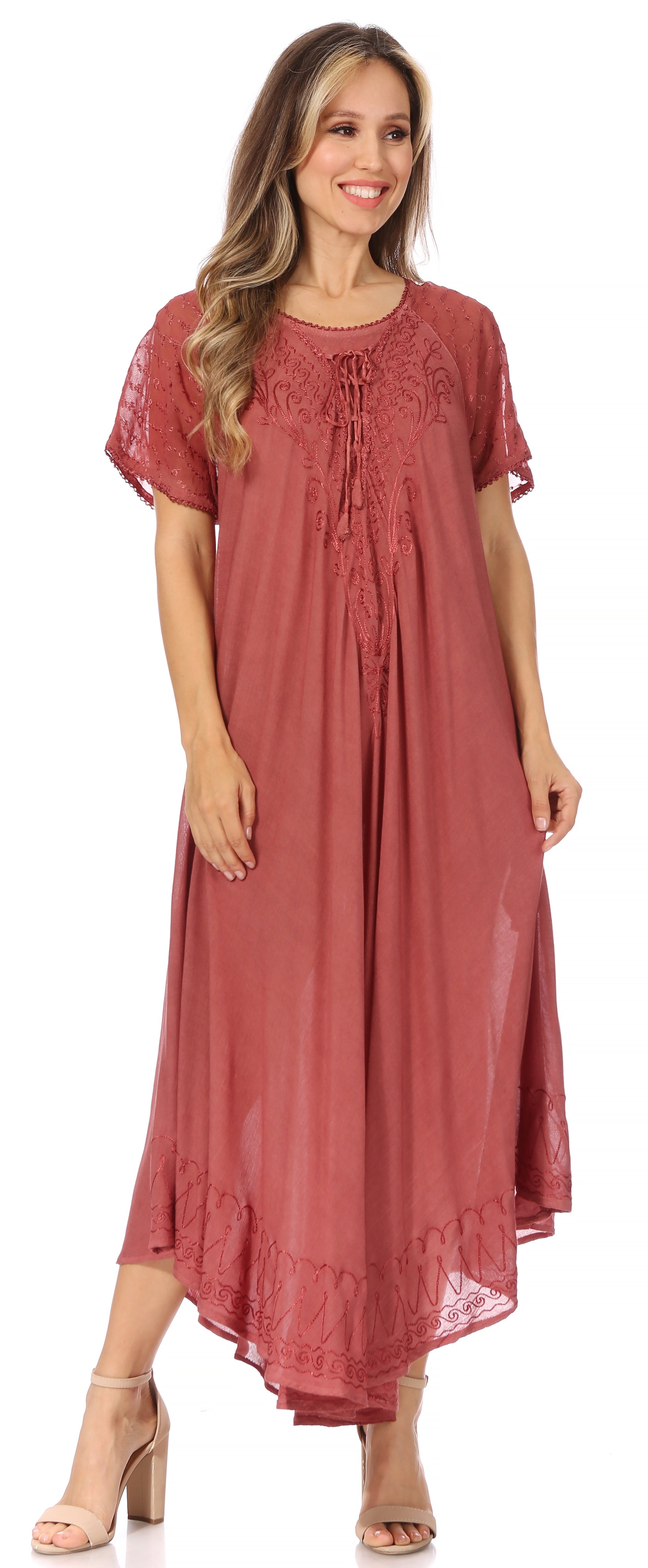 Woman wearing a long rust-colored dress with lace details on a white background