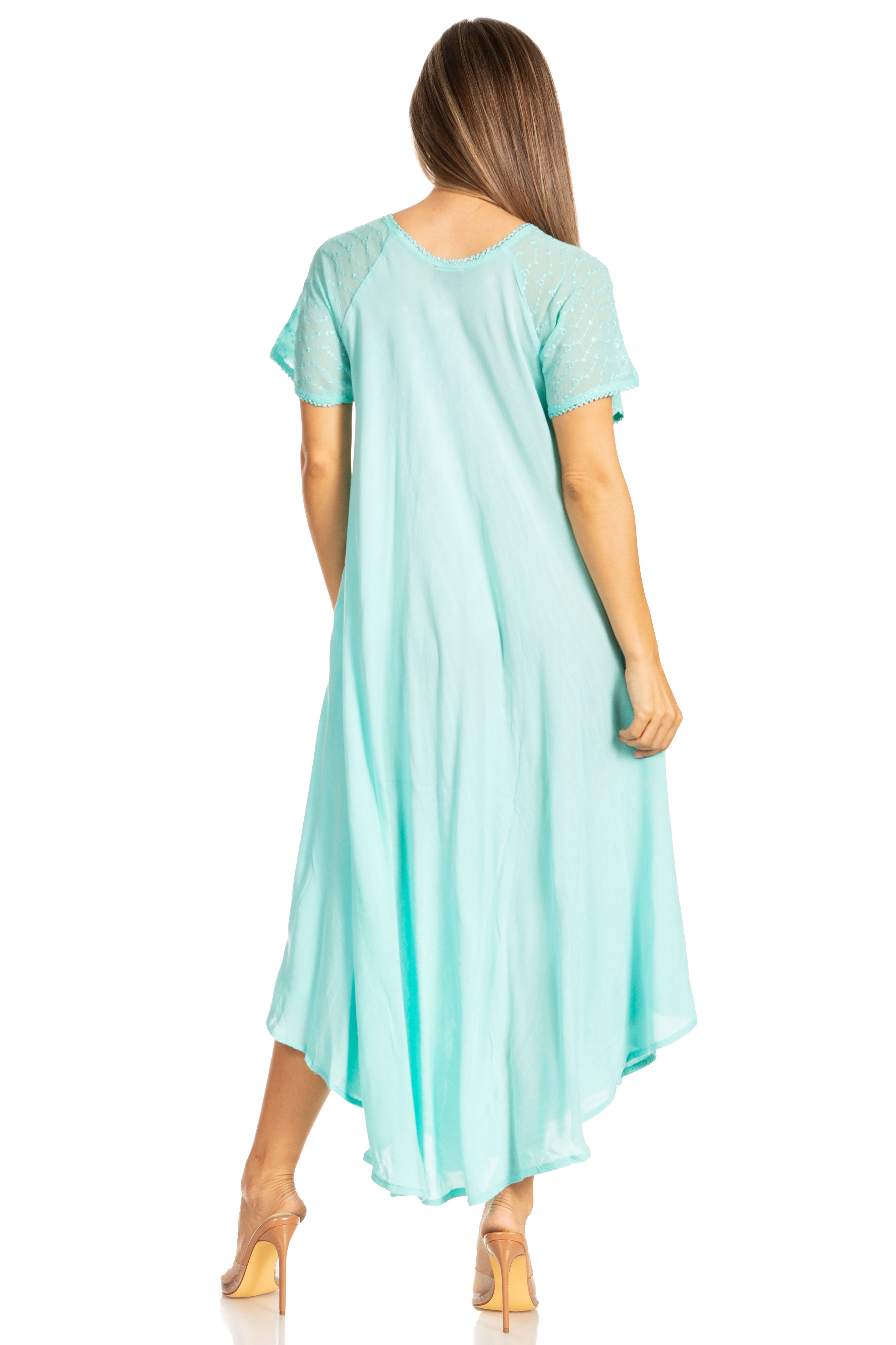 Woman wearing a long, flowing blue-colored dress with lace sleeves on a white background