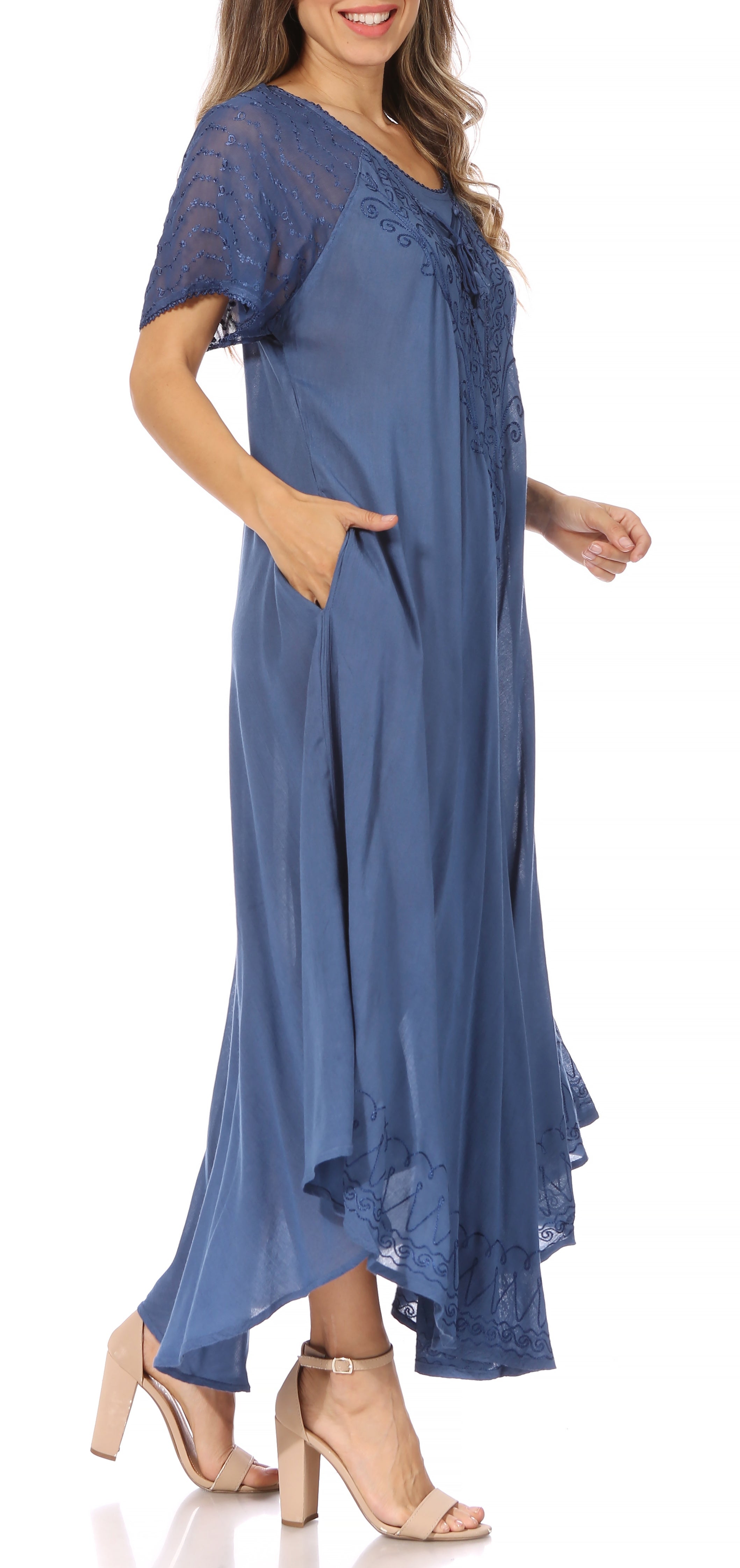 Woman wearing a long, flowing rust-colored dress with lace sleeves on a white background