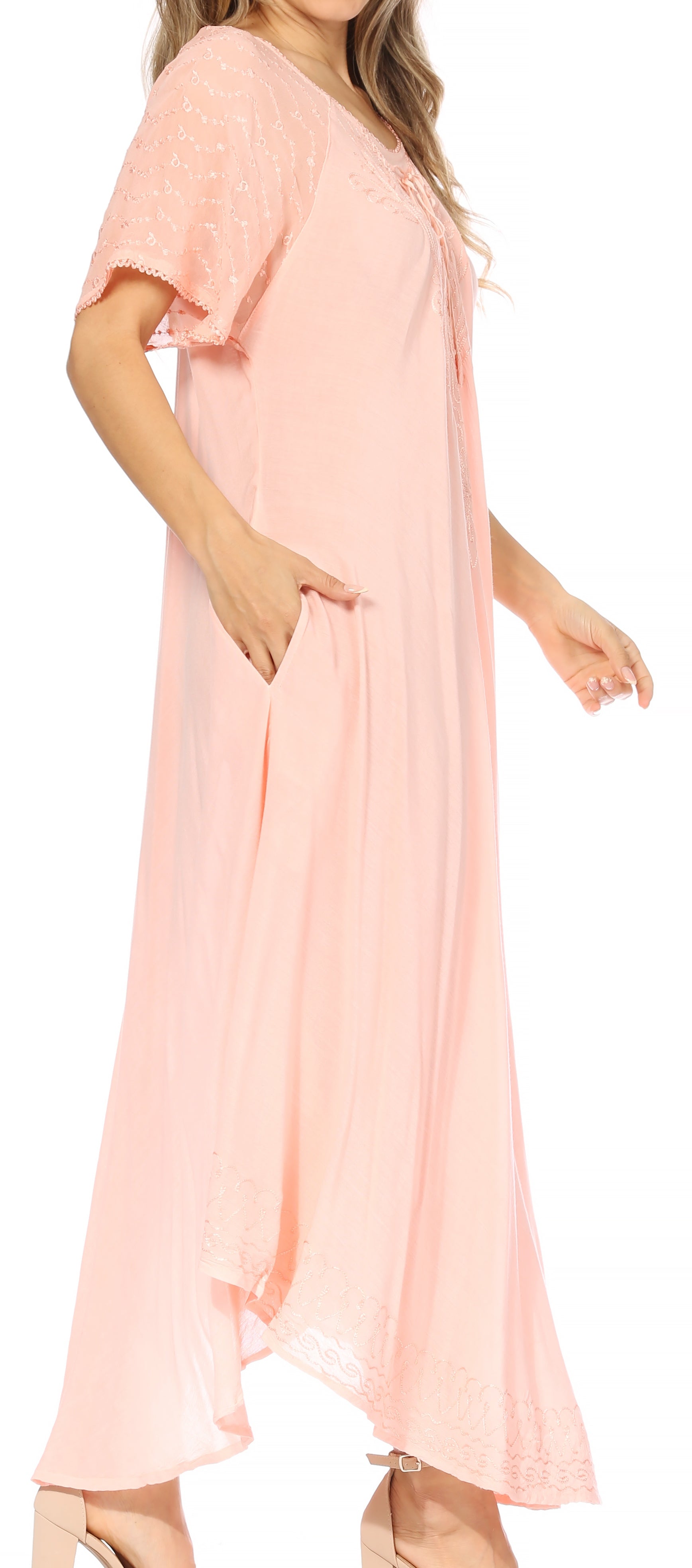 Woman wearing a light pink dress with short sleeves and a flowing skirt.