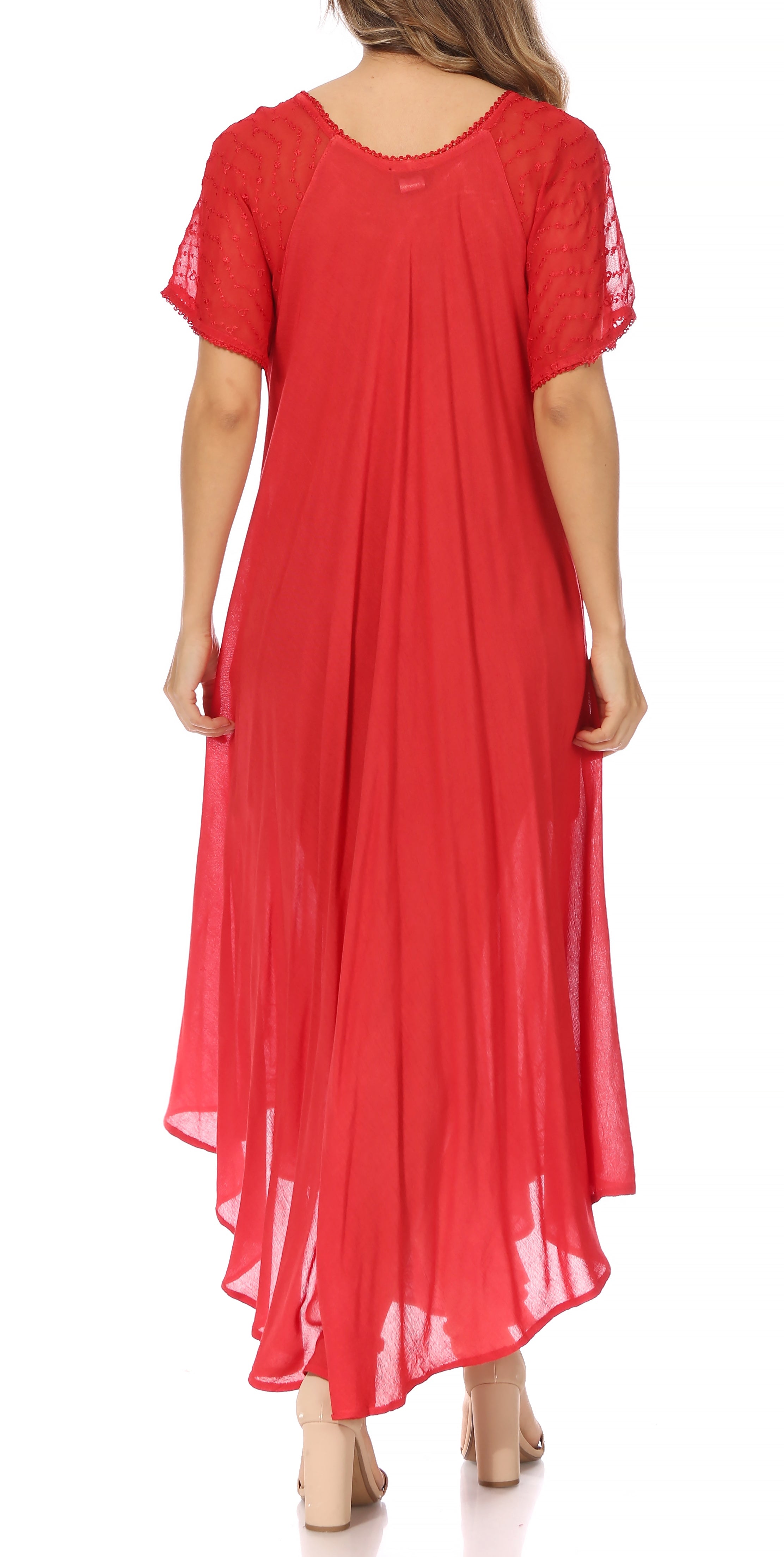 Woman wearing a long, flowing red colored dress with lace sleeves on a white background