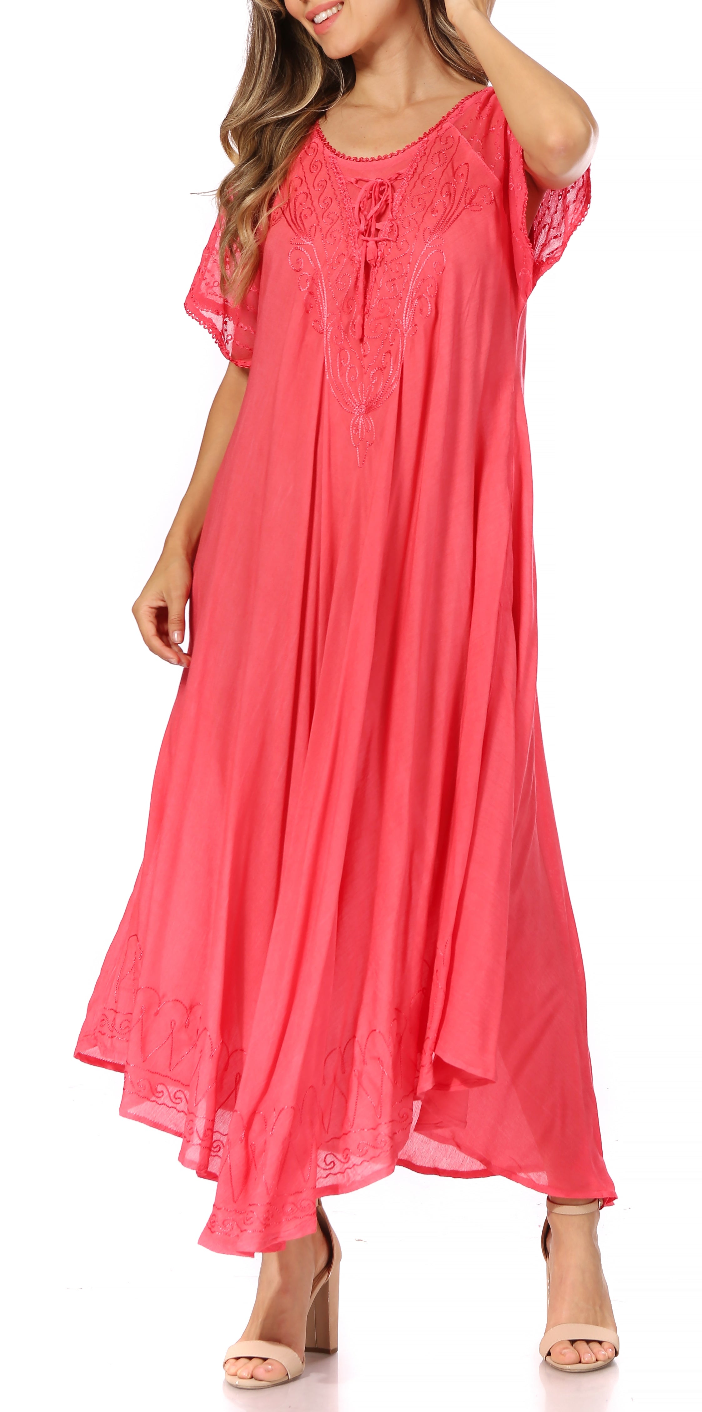 Woman wearing a coral pink dress with lace details on a white background