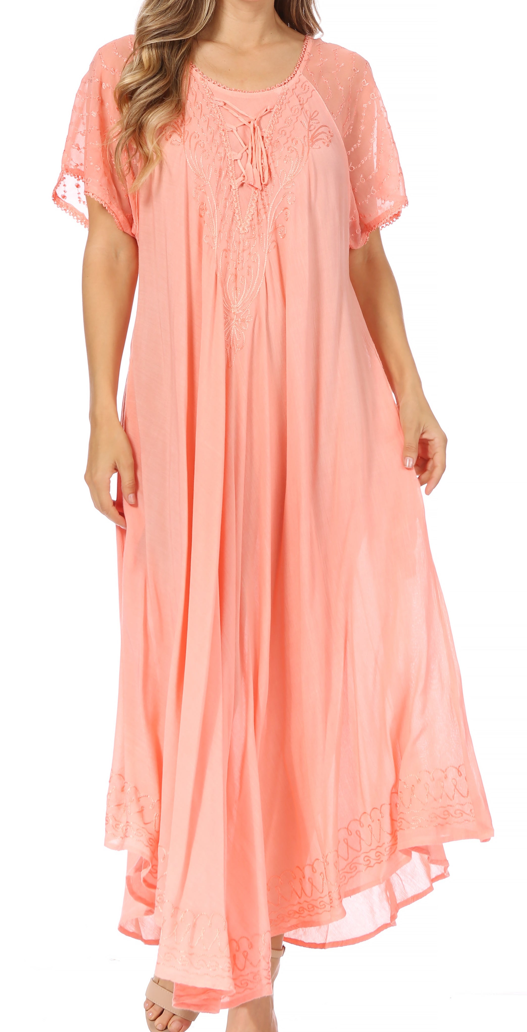 Woman wearing a peach-colored dress with lace details on a white background