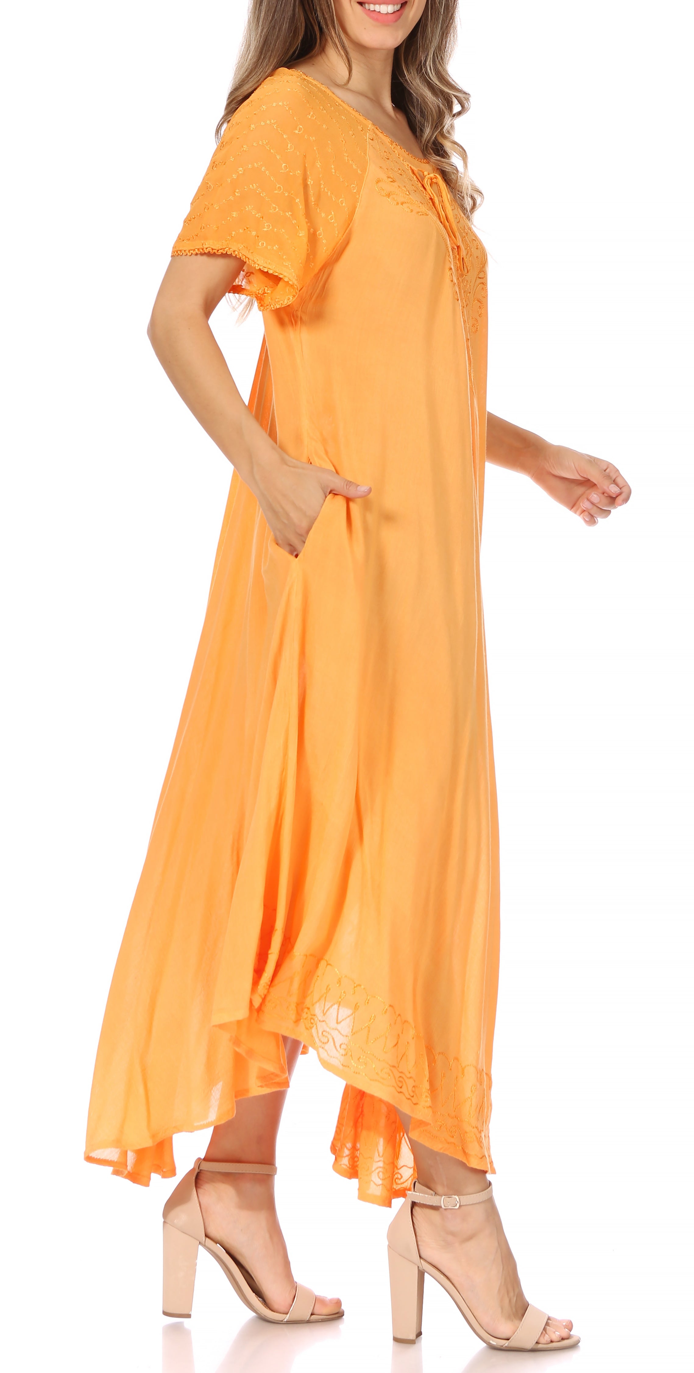 Woman wearing a long, flowing rust-colored dress with lace sleeves on a white background