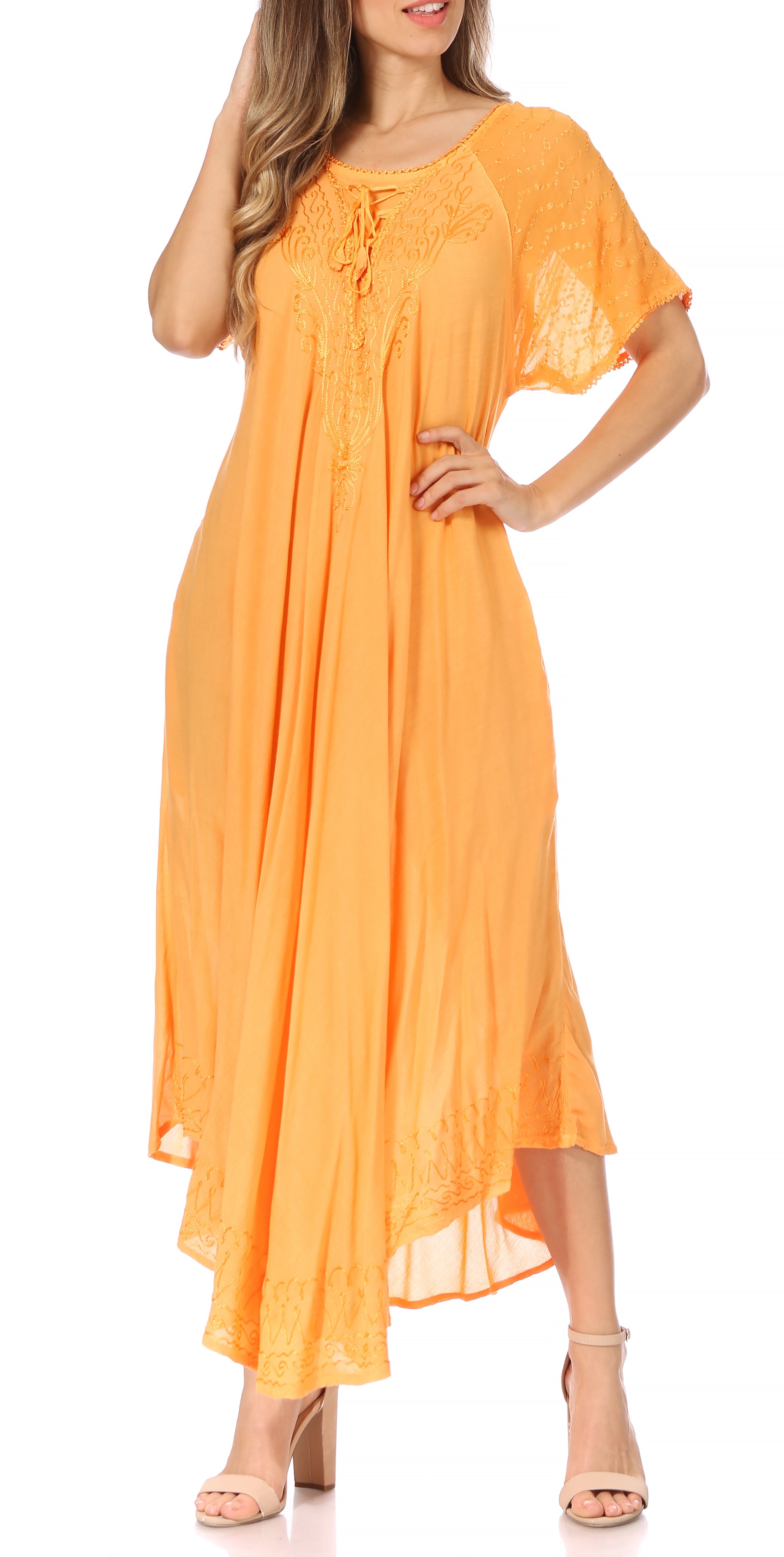 Woman wearing a long, flowing rust-colored dress with lace sleeves on a white background