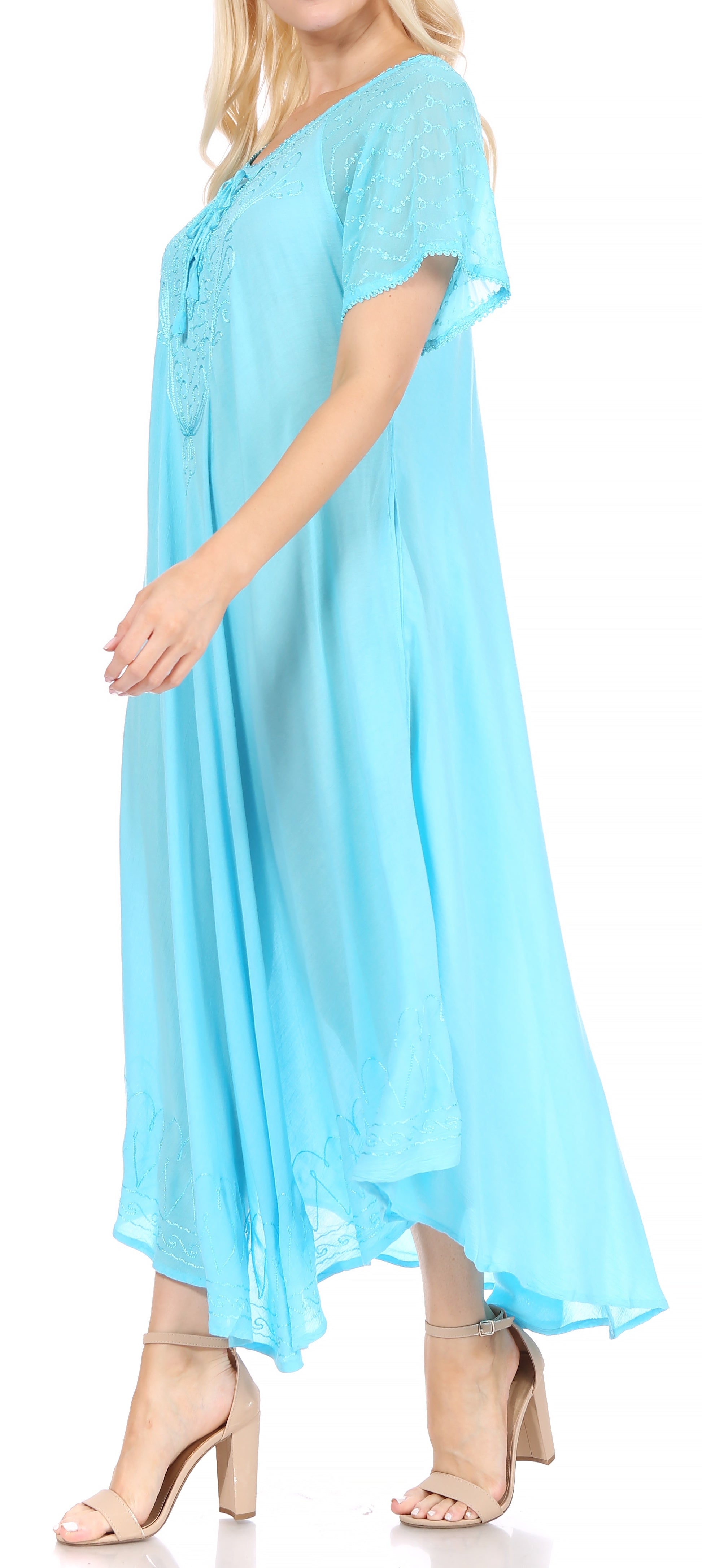 Woman wearing a long, flowing blue-colored dress with lace sleeves on a white background