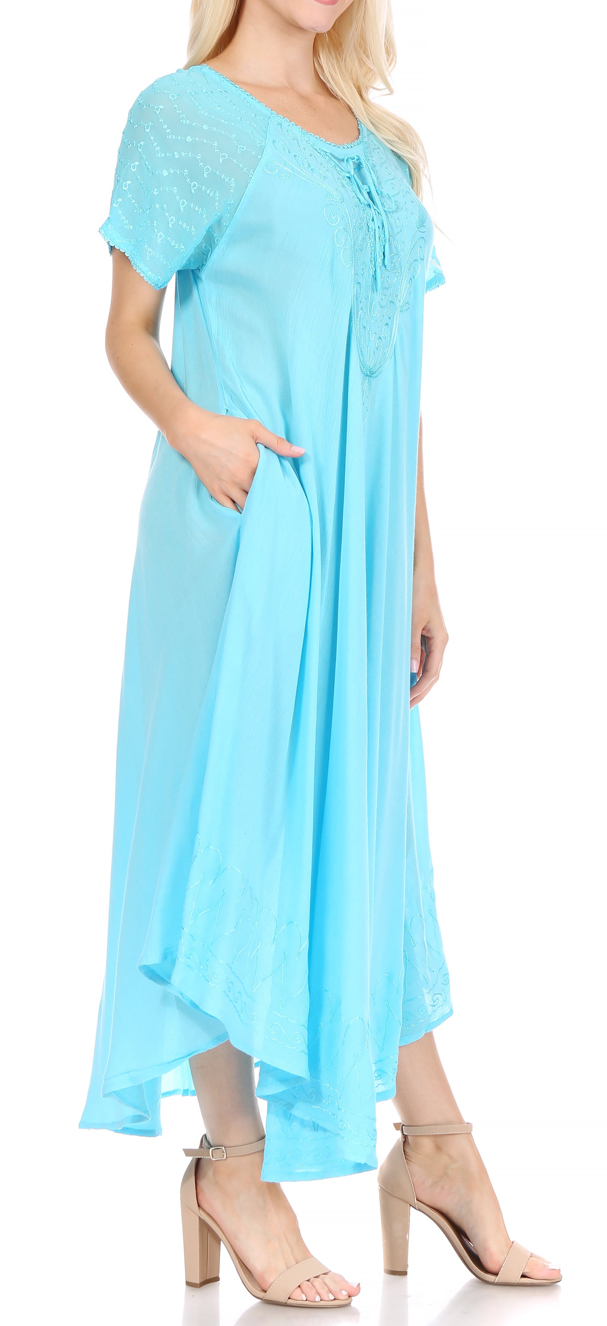 Woman wearing a light blue dress with short sleeves and a flowing skirt.