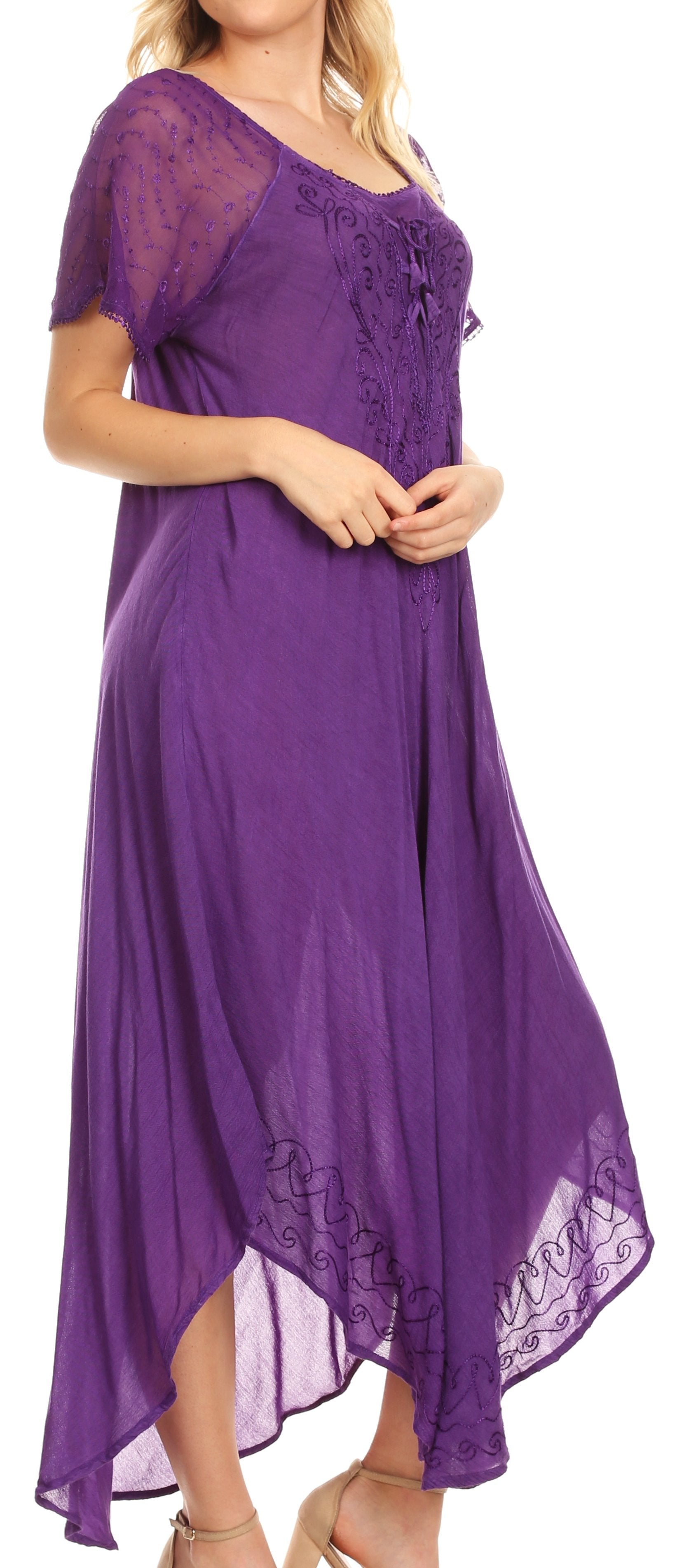 Woman wearing a purple dress with lace details on a plain background