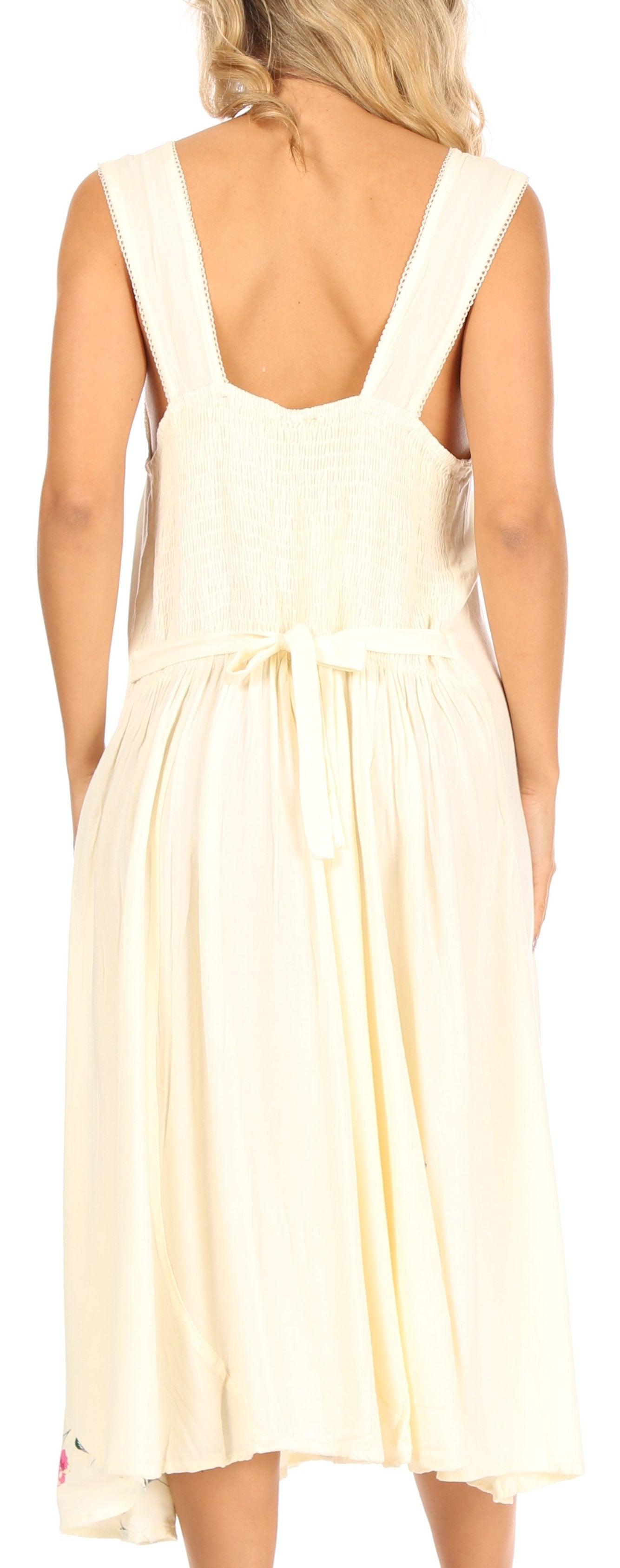 Woman wearing a light-colored dress with thin straps.