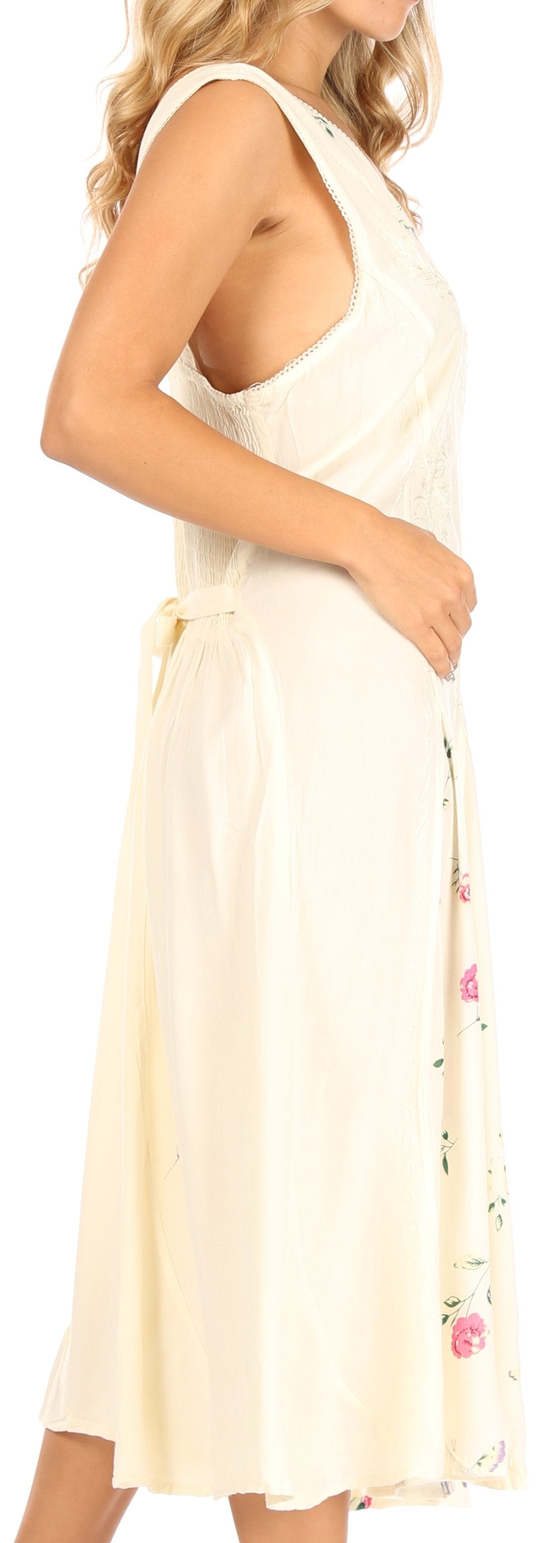 Woman wearing a light-colored dress with floral details on a plain background